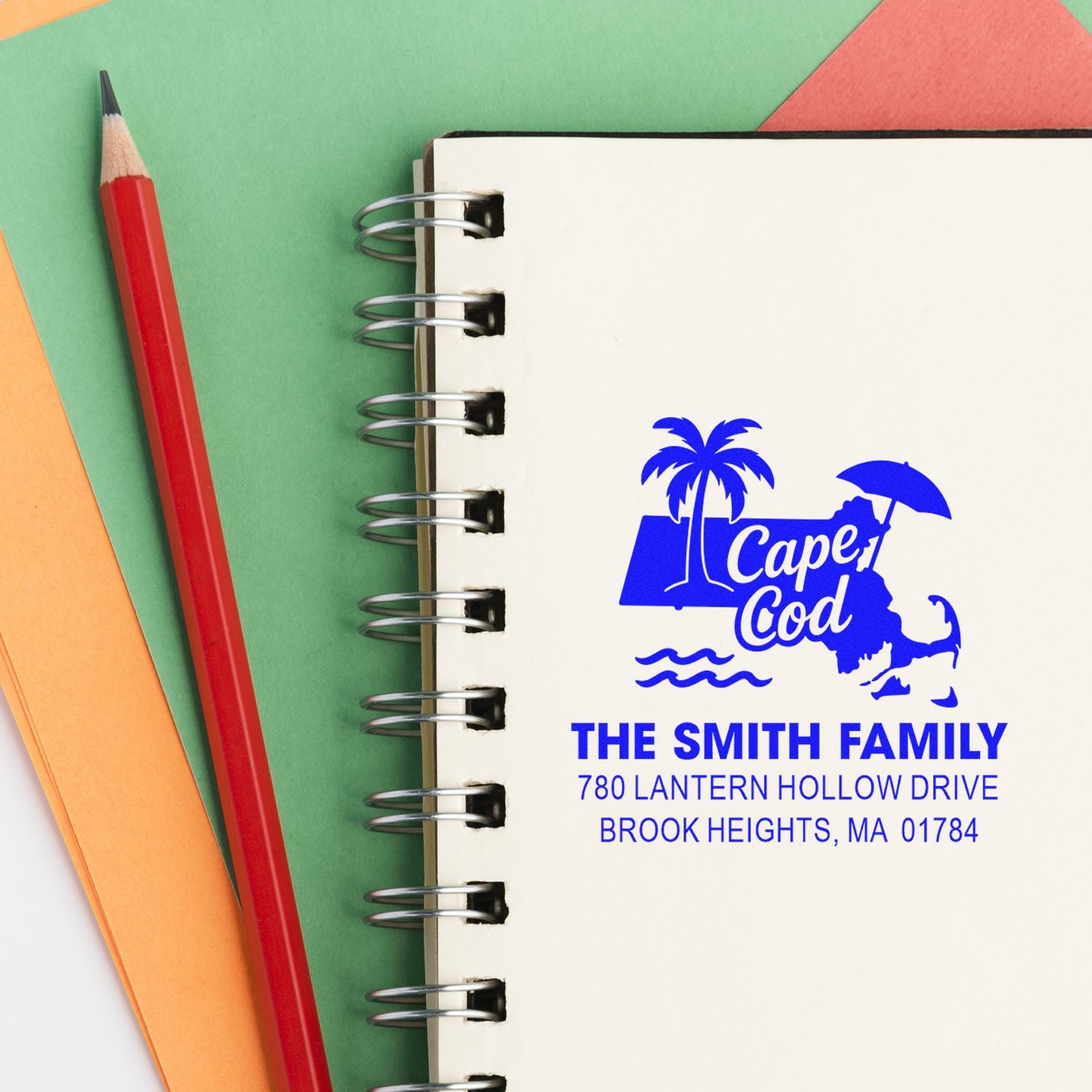 Personalized return address rubber stamp with Cape Cod design for The Smith Family on a spiral notebook.