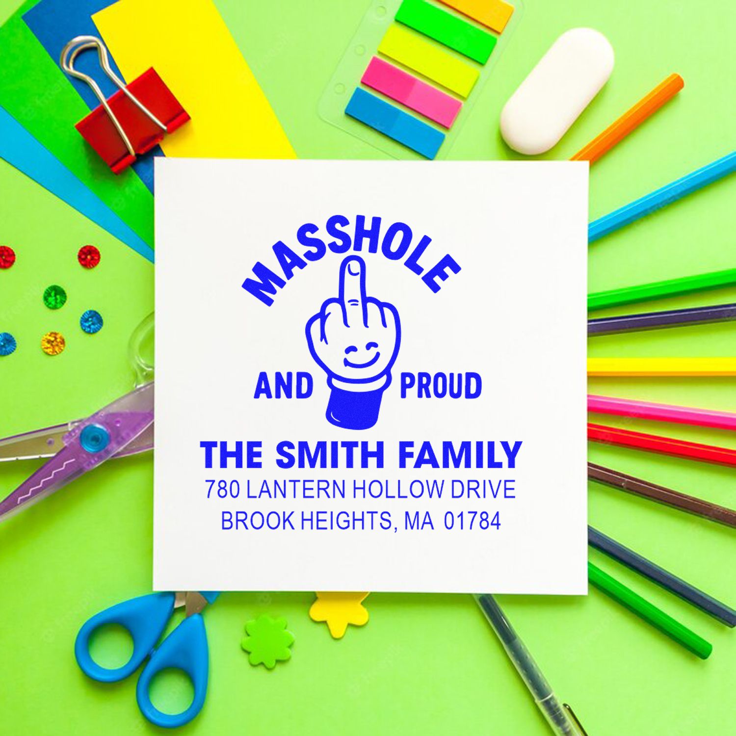 Custom rubber address stamp with Masshole and Proud design and Smith family return address, shown with colorful school supplies.