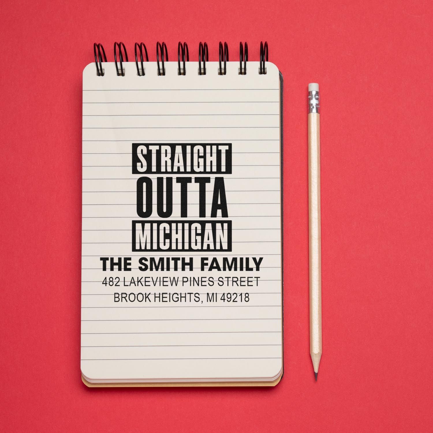 Custom rubber stamp mockup reading Straight Outta Michigan with family name and address for personalized address stamping.