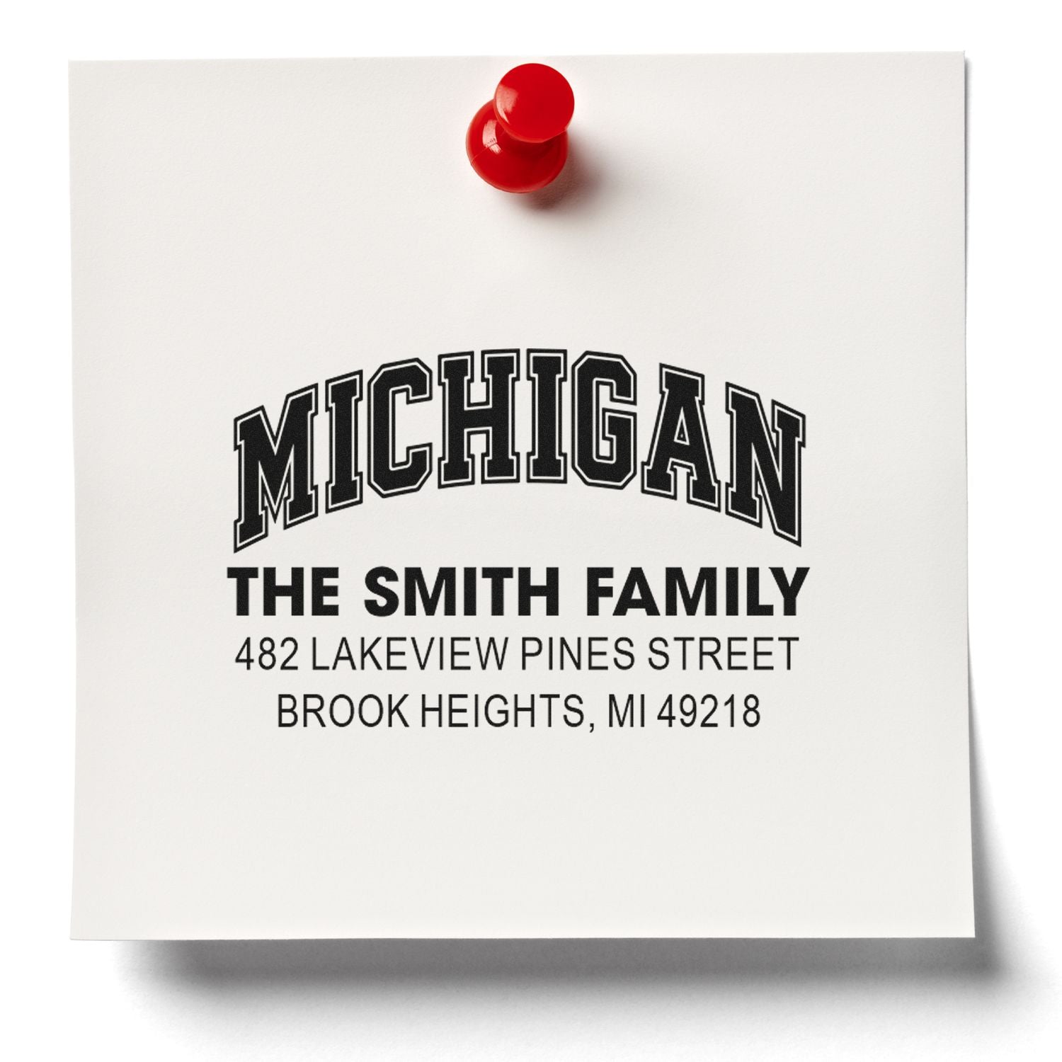 Custom return address rubber stamp for The Smith Family, featuring Michigan address on paper with red pushpin.