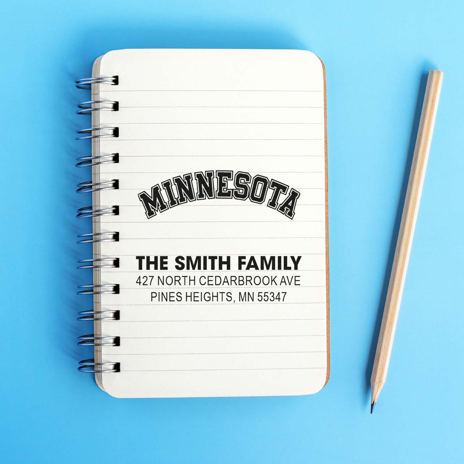 Custom return address rubber stamp for The Smith Family, with Minnesota location and mailing details on a notebook.