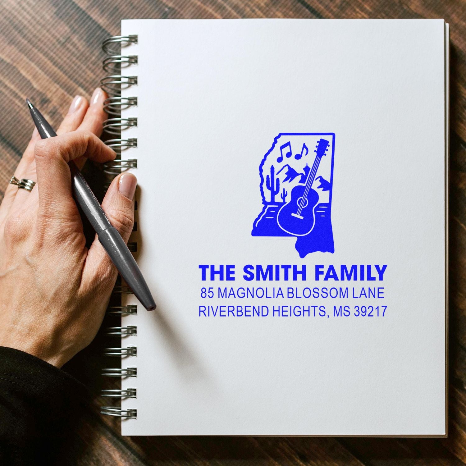 Custom family return address rubber stamp with Mississippi guitar design stamped on personalized stationery.