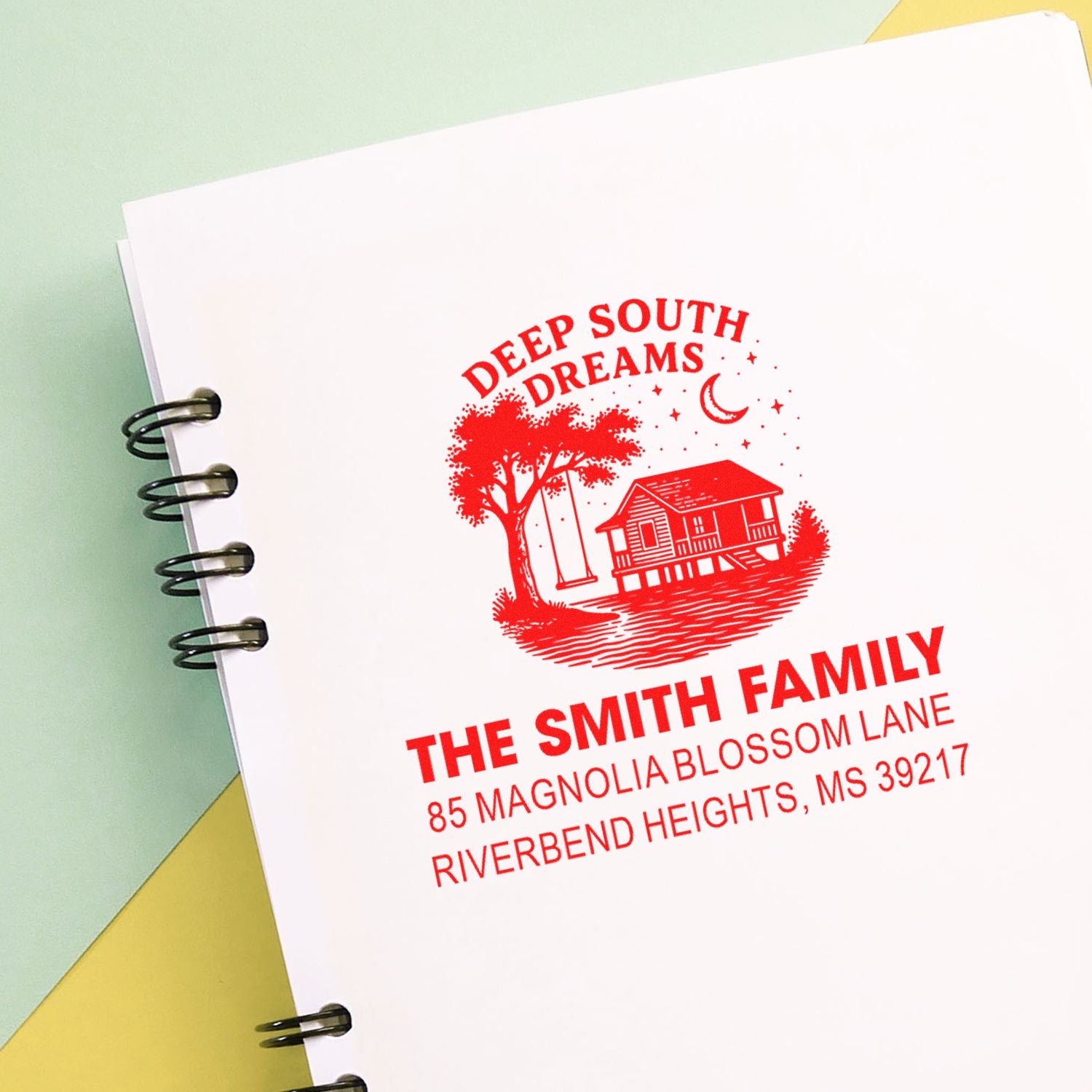Personalized rubber return address stamp for The Smith Family with Deep South Dreams design, shown in red on notebook paper.