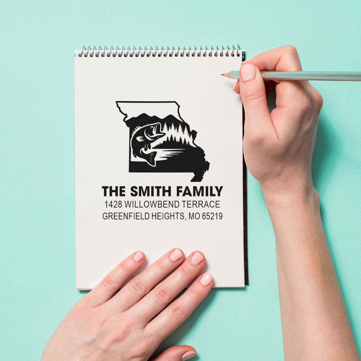 Custom return address rubber stamp with Missouri state fish design, Smith family name, and home address on a notebook.