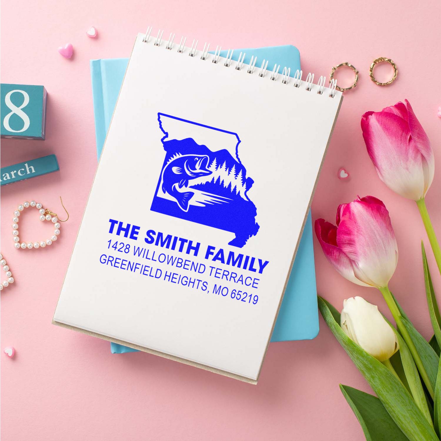 Custom family address rubber stamp with Missouri bass fishing design and return address, displayed on a notebook.