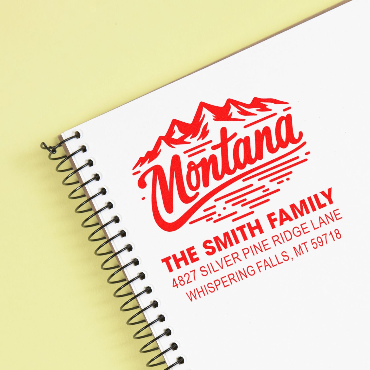 Custom Montana return address rubber stamp on spiral notebook, featuring The Smith Family and Whispering Falls, MT.