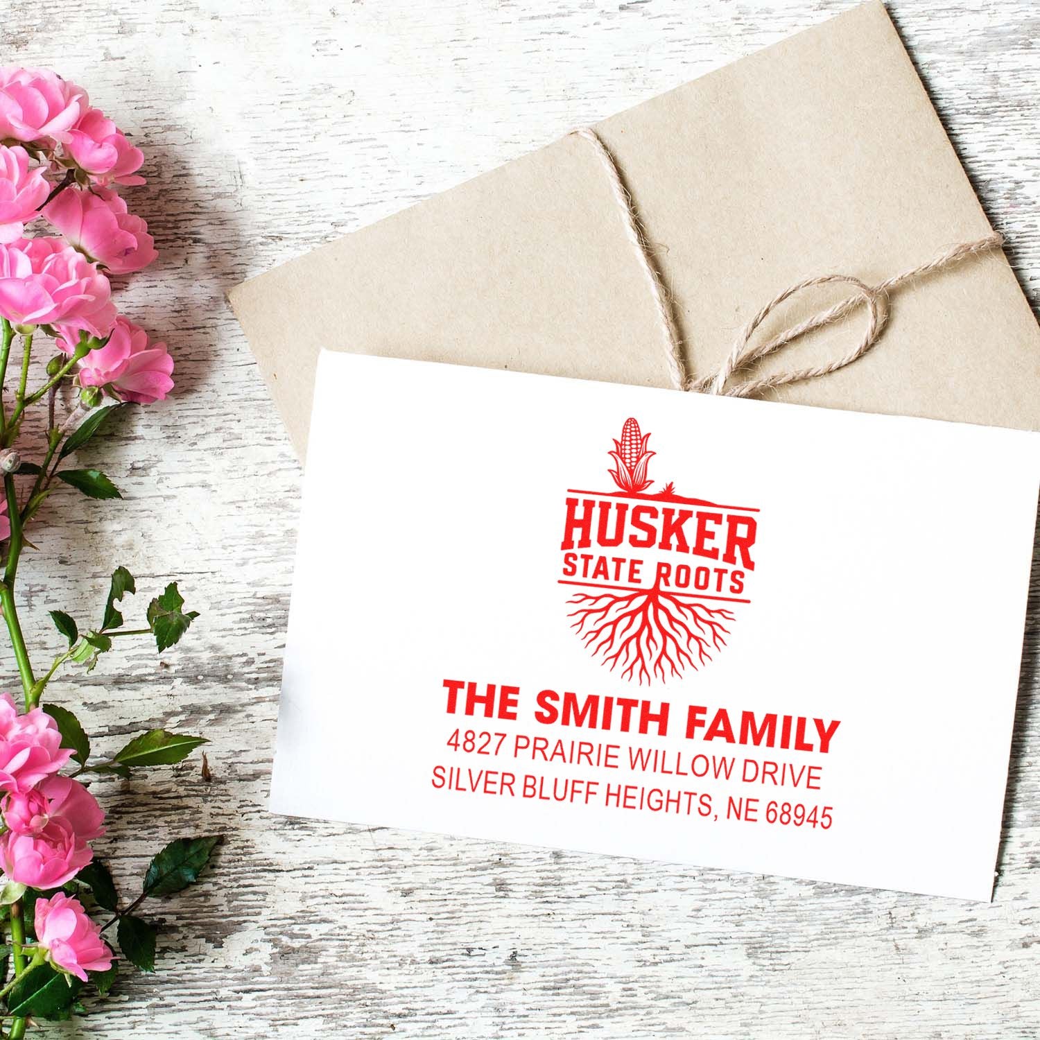 Custom red return address rubber stamp for family envelopes, featuring a Husker State Roots Nebraska address design.