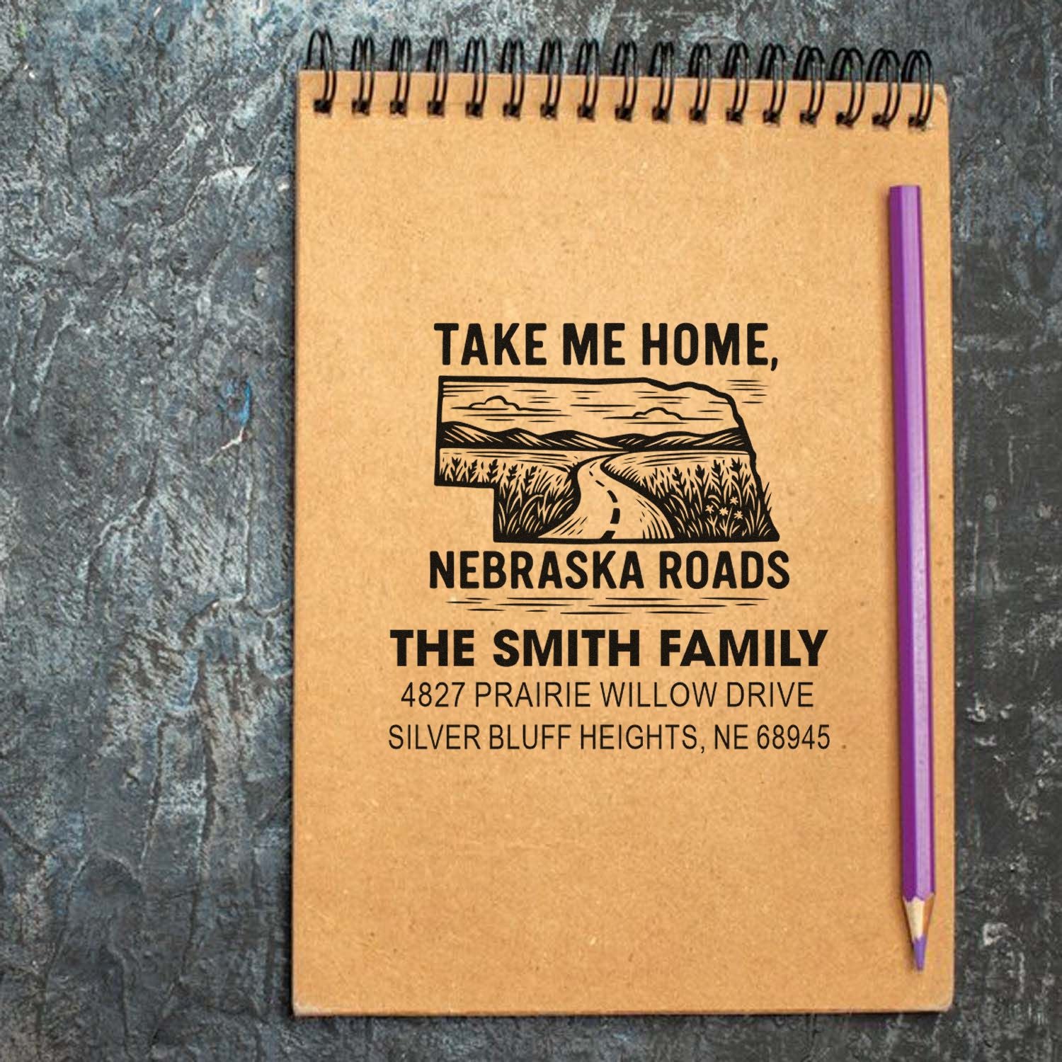 Personalized address rubber stamp imprint for The Smith Family, featuring Nebraska roads and return address design on kraft notebook.