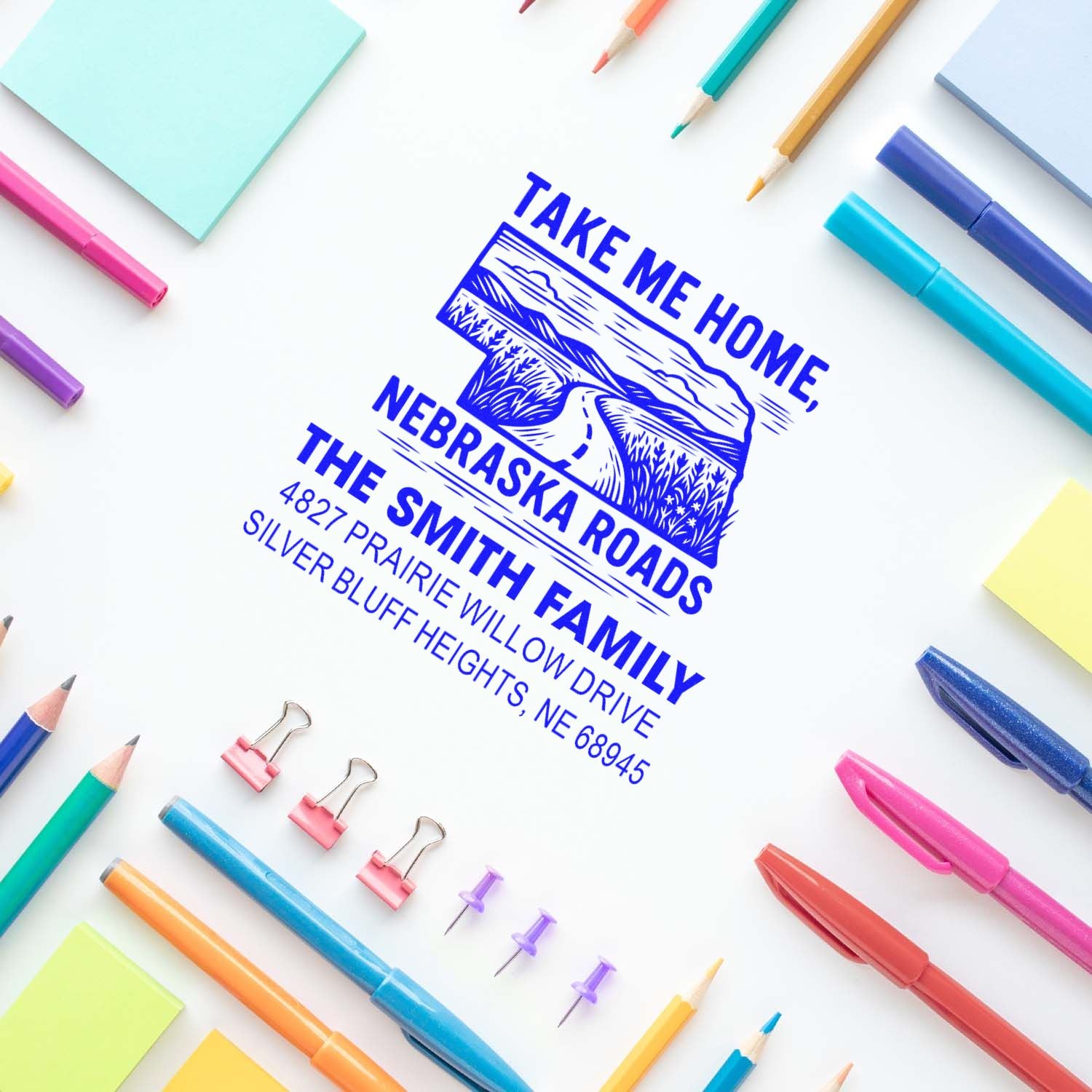 Custom rubber address stamp featuring Nebraska roads design for The Smith Family on stationery with colorful pens.