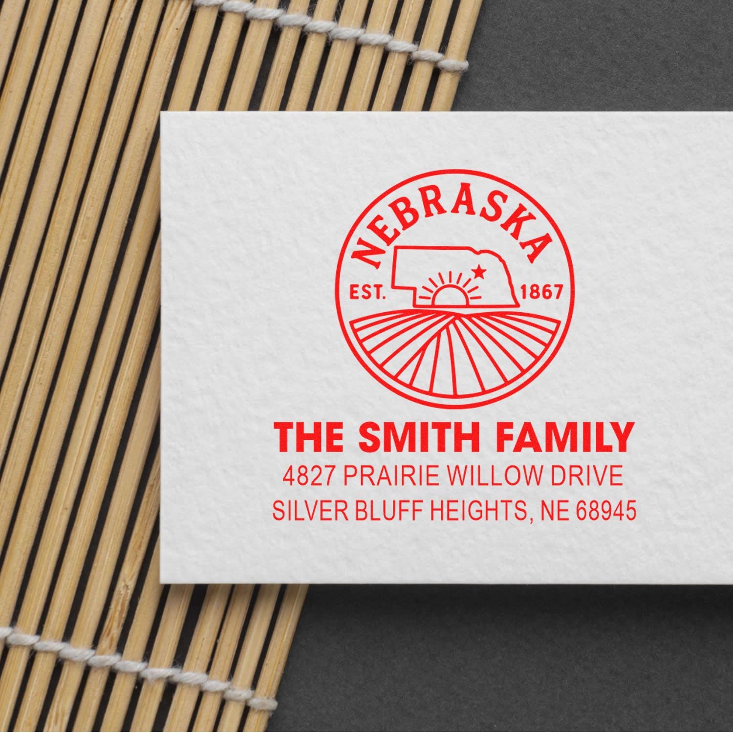 Custom return address rubber stamp sample for The Smith Family, Nebraska, with red logo and address imprint.