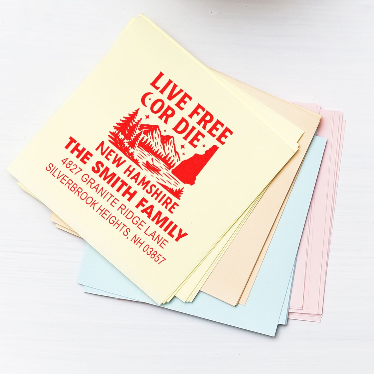 Custom return address rubber stamp for a New Hampshire family on assorted stationery paper.