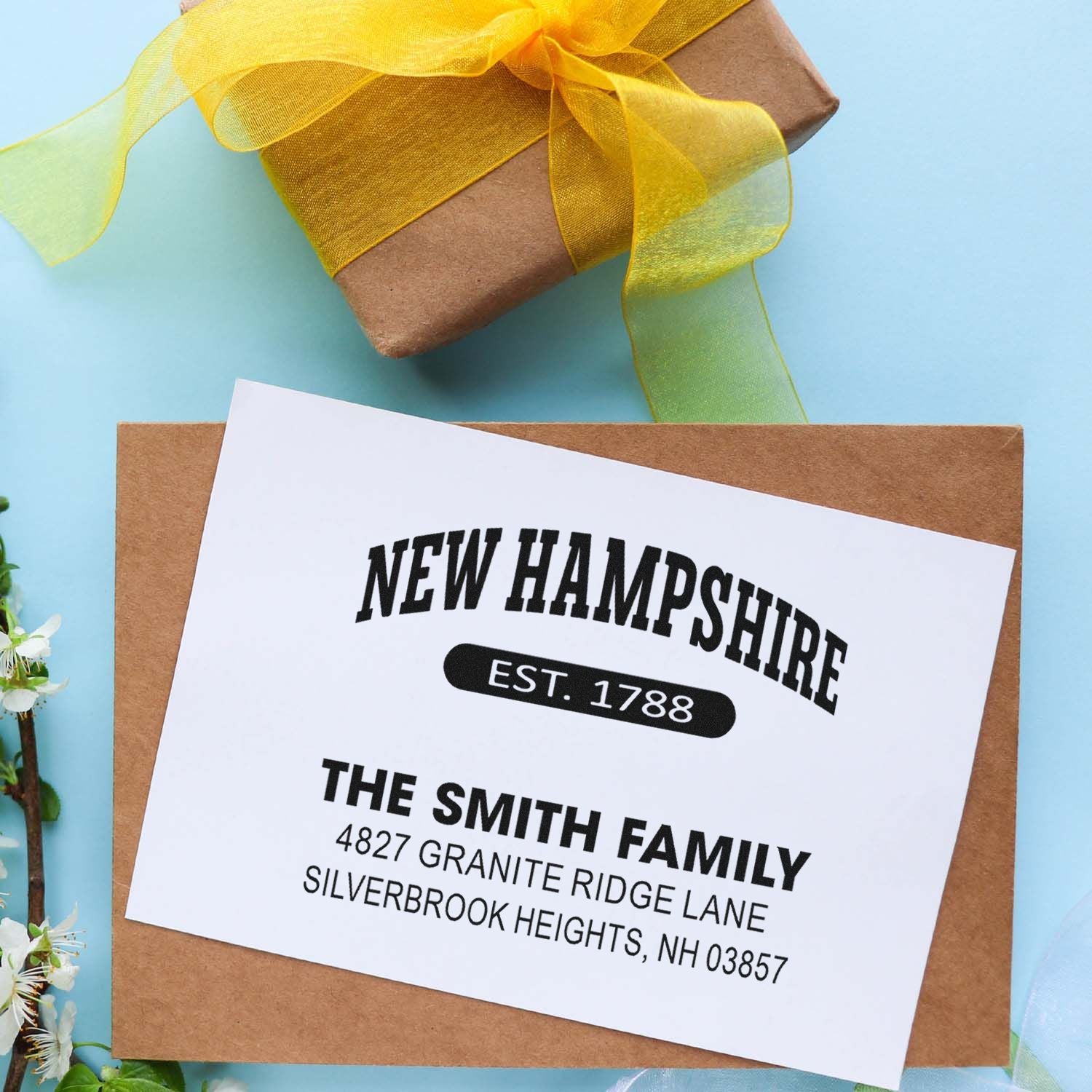Custom rubber stamp design on gift wrap with New Hampshire family name and return address.