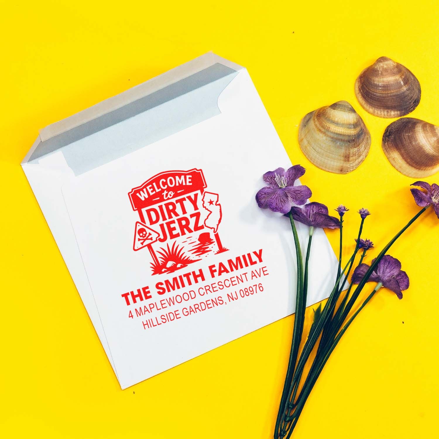 Custom rubber stamp on white mailing envelope with Welcome to Dirty Jerz family address design for personalized packaging.