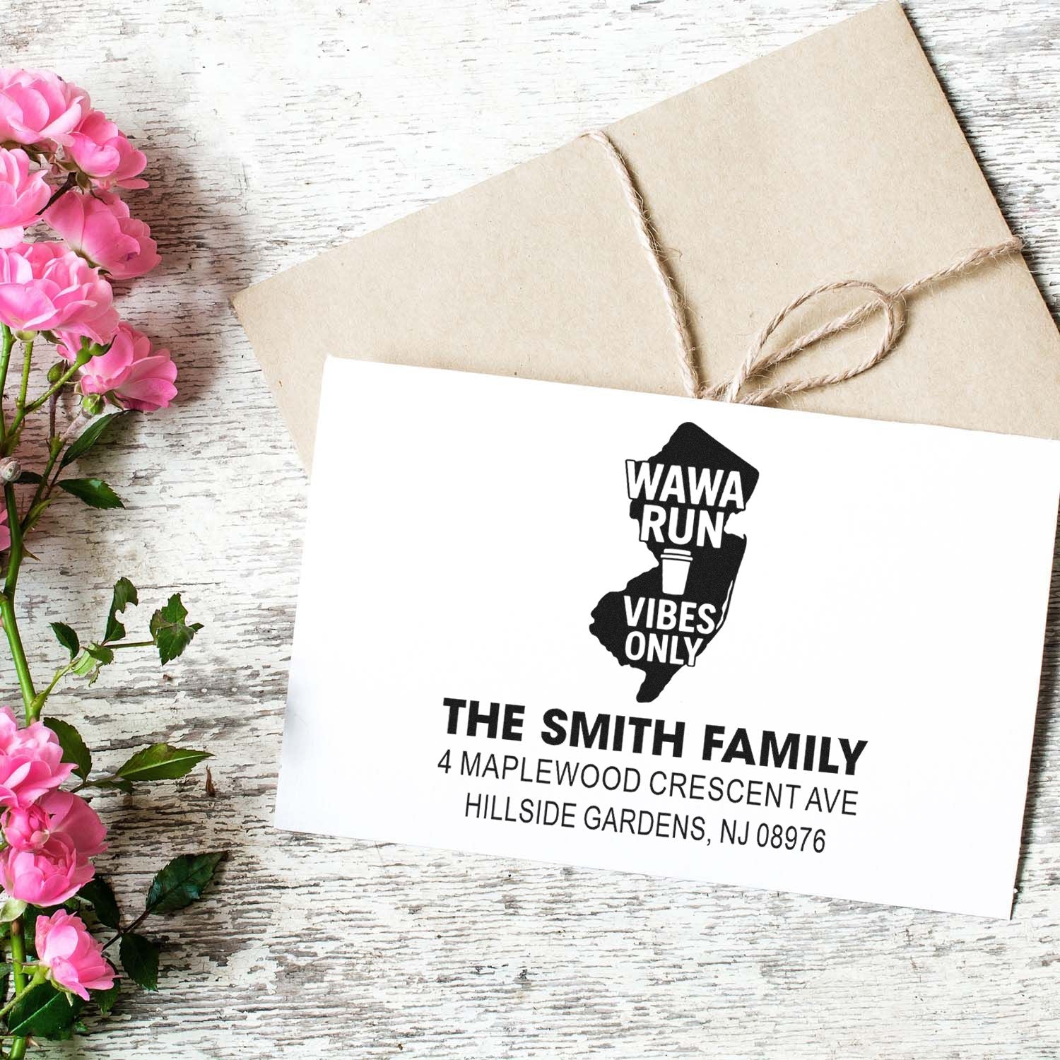 Custom return address rubber stamp on envelope, personalized with family name, NJ address, and state silhouette design.