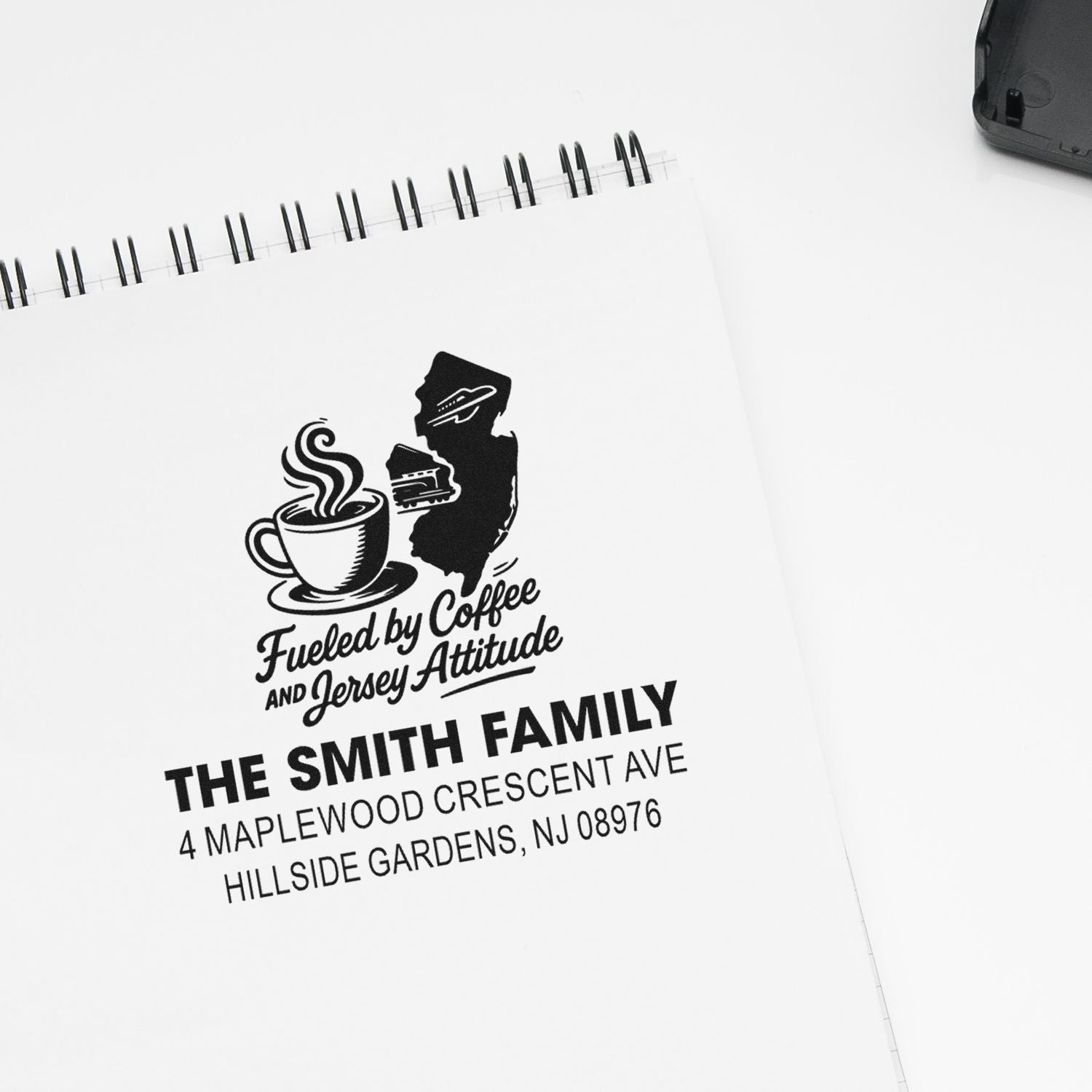 Personalized rubber stamp with coffee cup graphic and New Jersey family address on notebook, featuring Fueled by Coffee and Jersey Attitude.