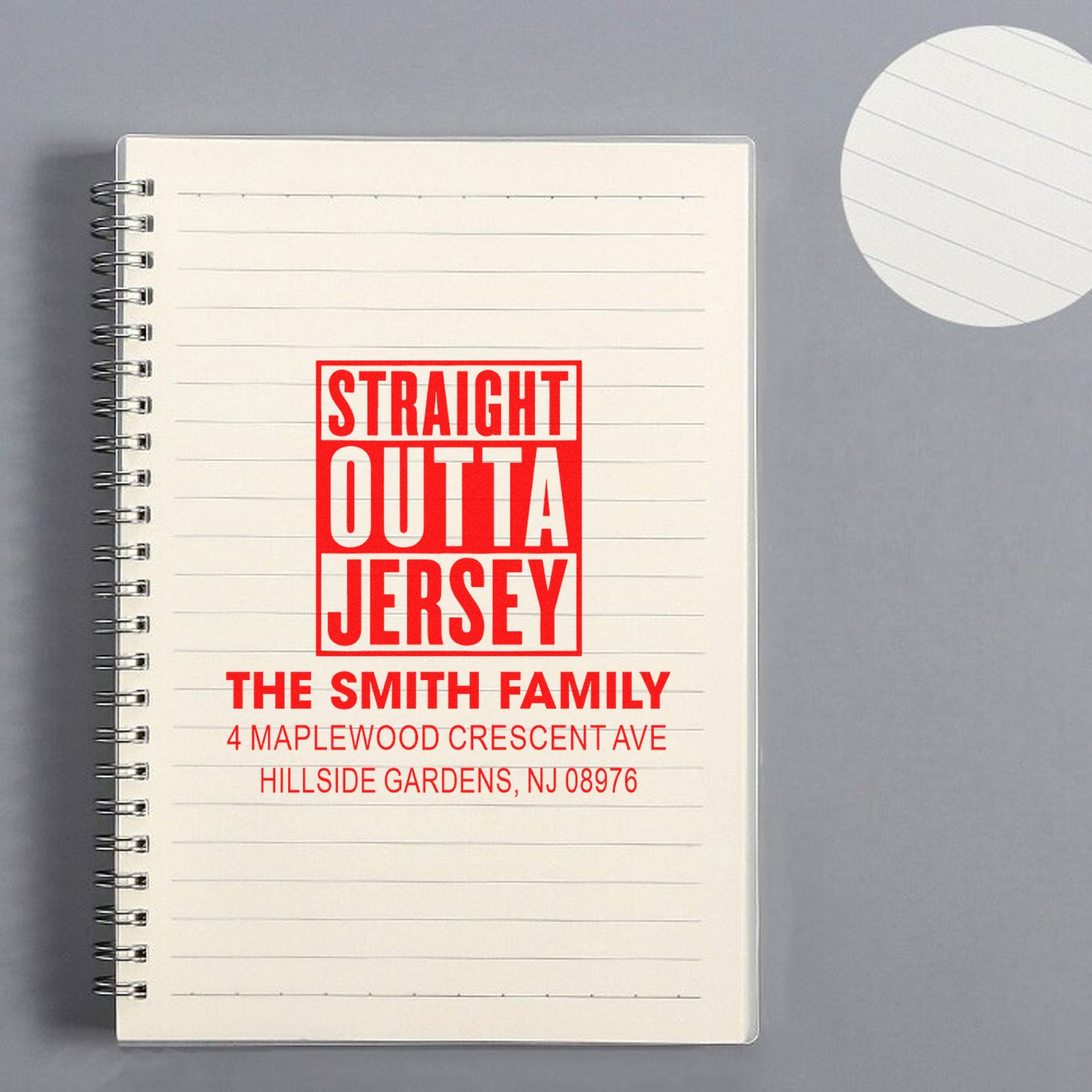 Custom return address rubber stamp reading Straight Outta Jersey for The Smith Family on a notebook.