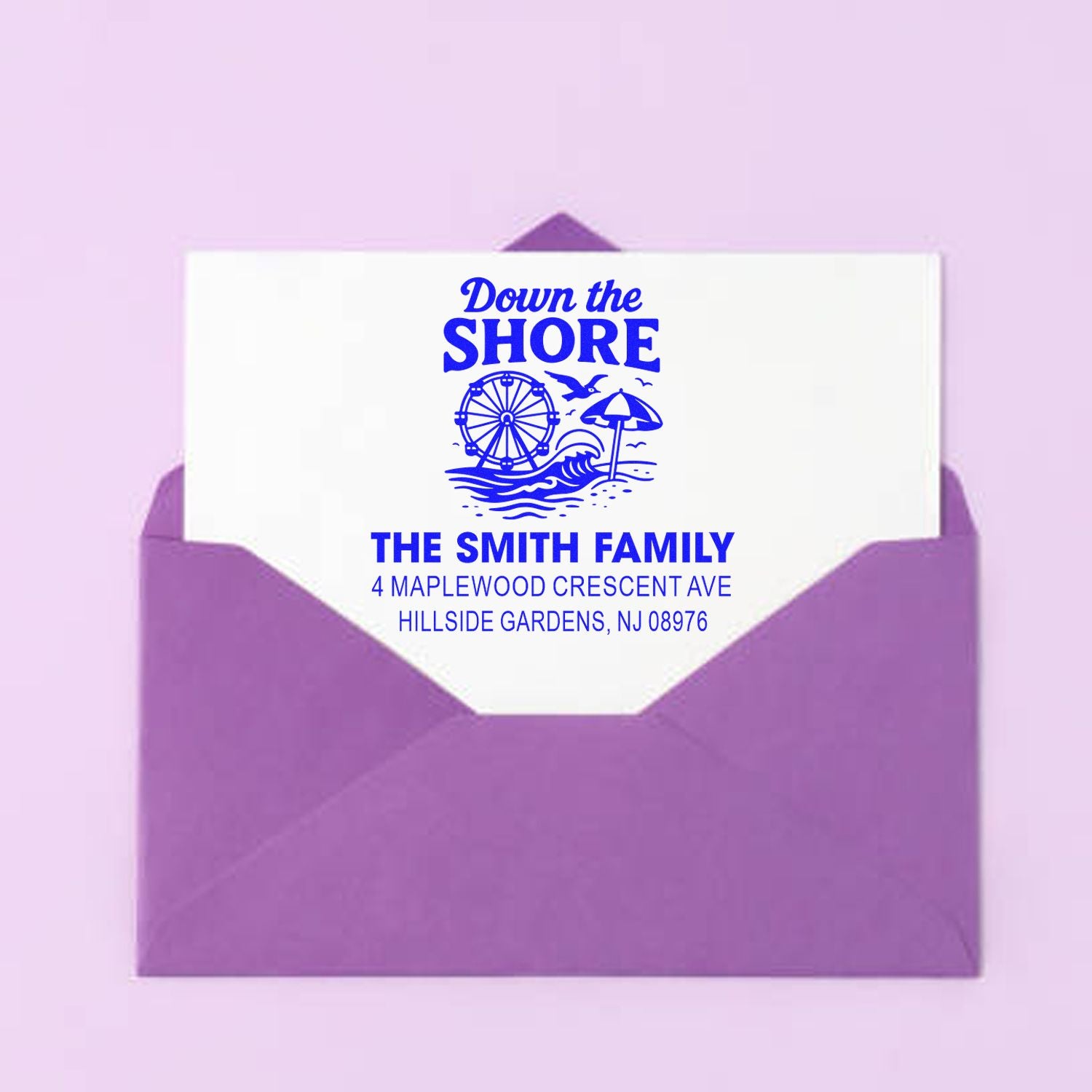 Personalized beach return address rubber stamp with Down the Shore design, family name, and address on a purple envelope.