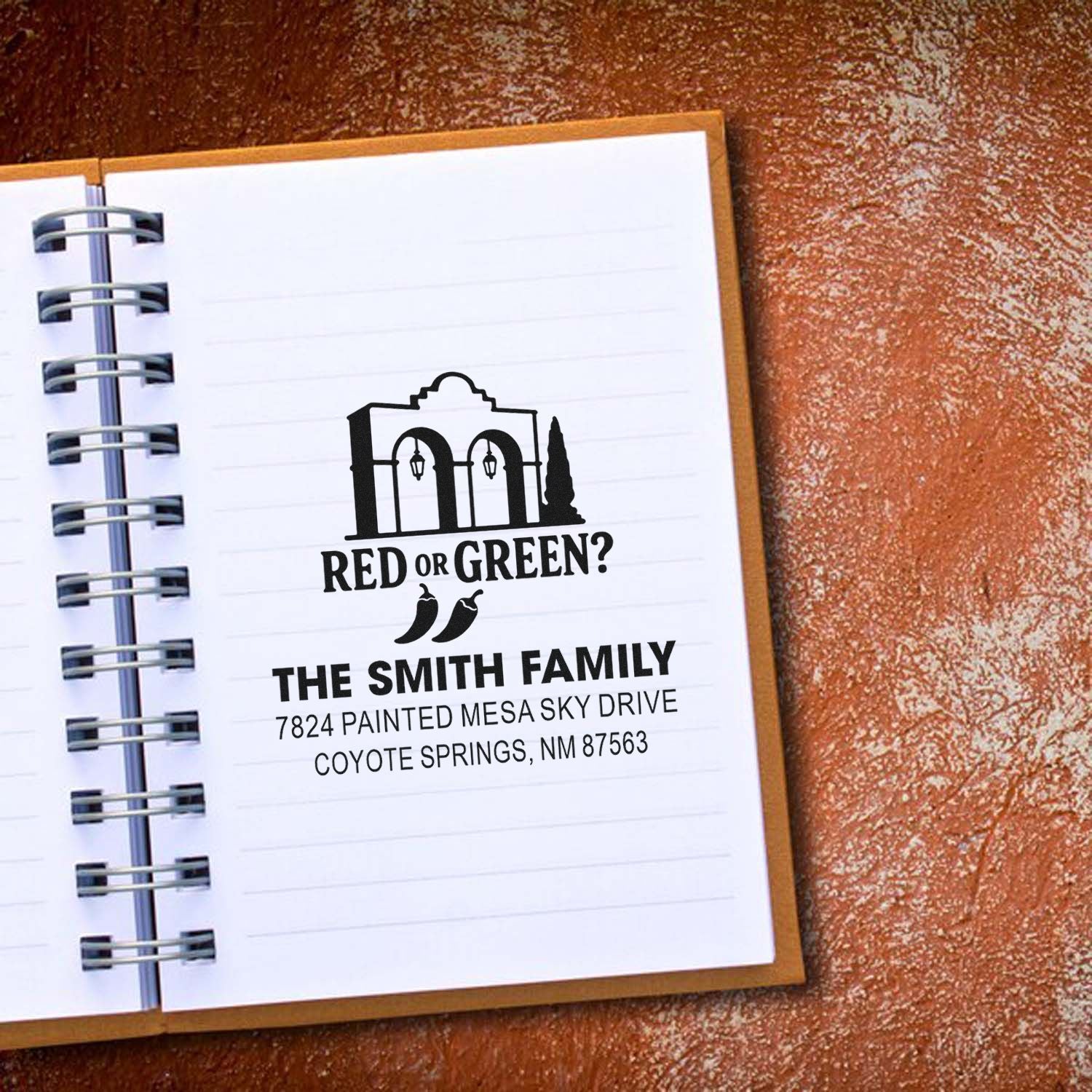 Custom rubber return address stamp with The Smith Family and Red or Green? design on a notebook page.