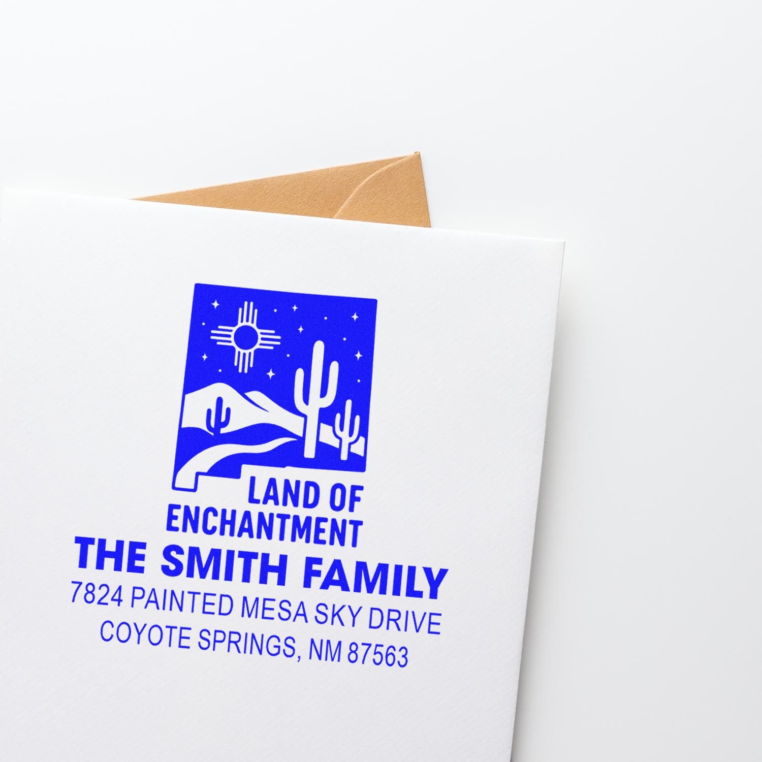 Blue custom return address rubber stamp with desert Land of Enchantment design for The Smith Family envelope