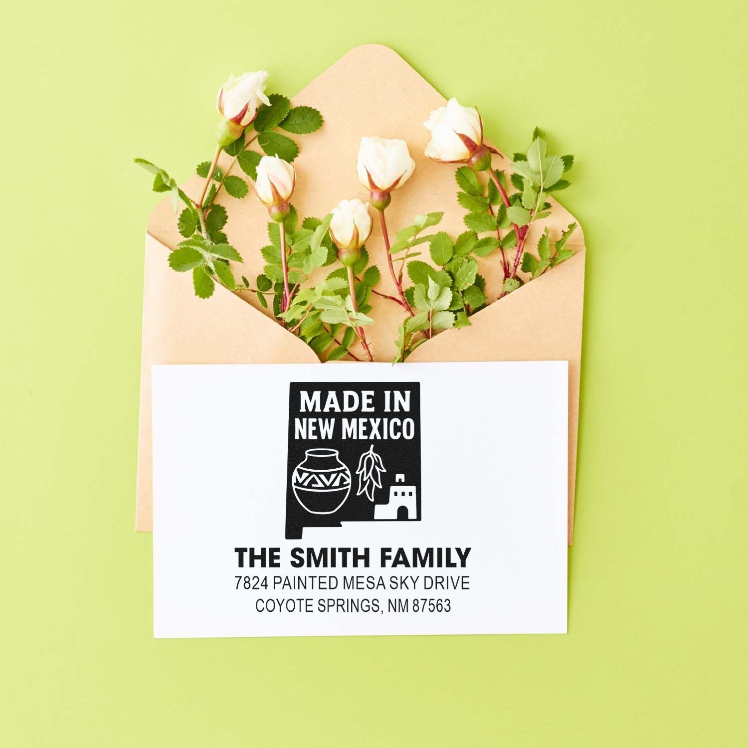 Custom Made in New Mexico rubber return address stamp for The Smith Family, shown on an envelope with flowers.