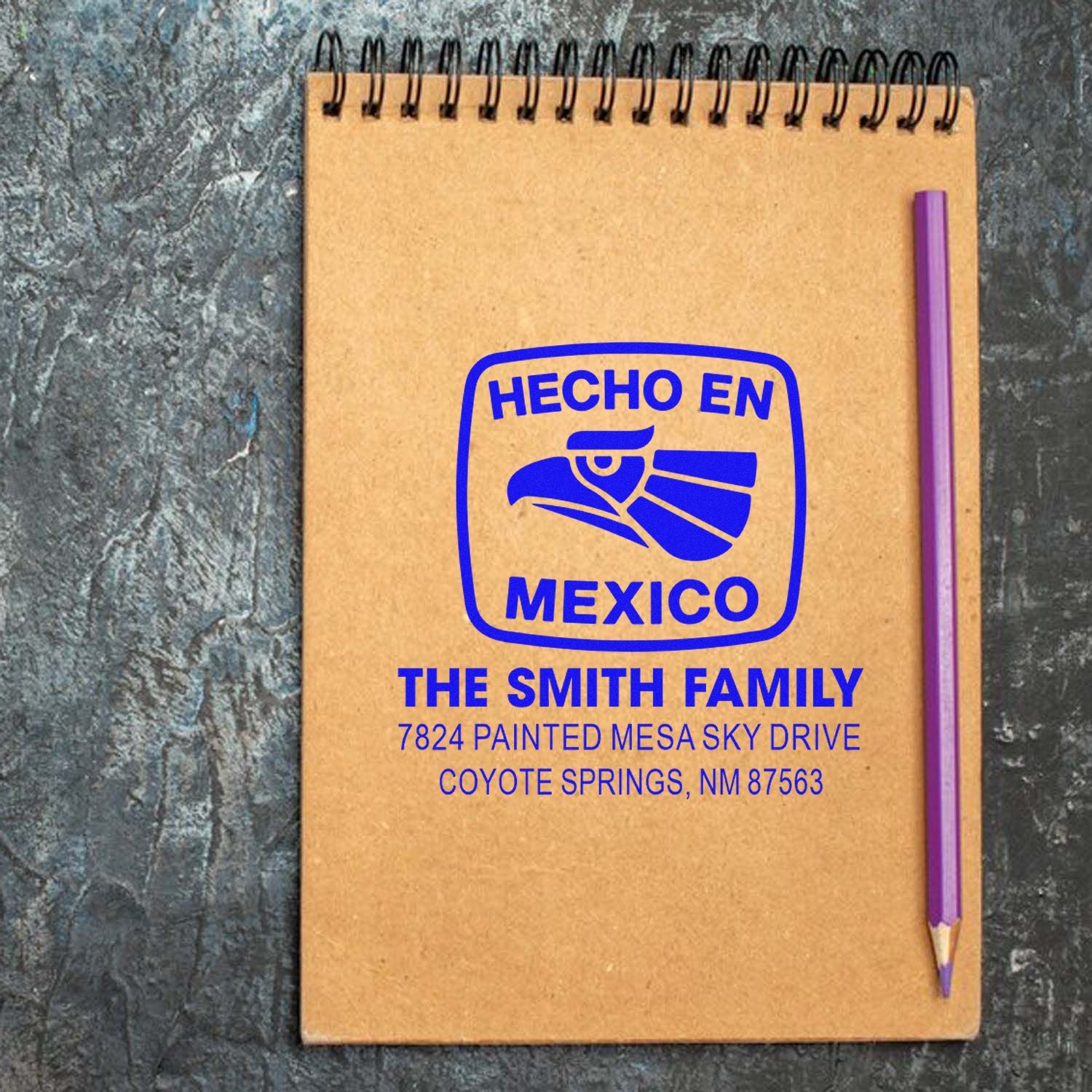 Custom Hecho en Mexico rubber stamp with family name and address, shown on notebook cover for personalized stationery.