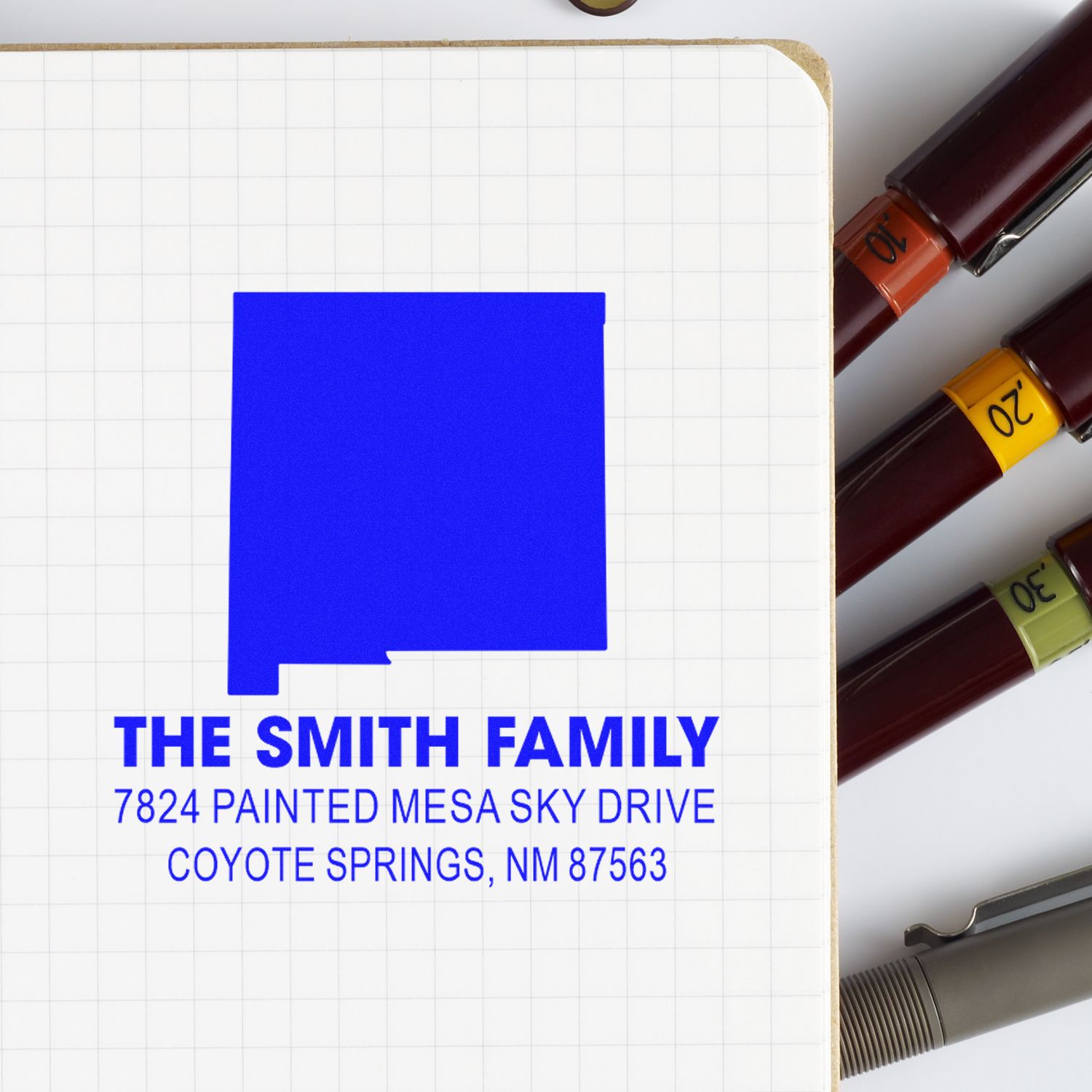 Personalized rubber address stamp for The Smith Family, featuring a blue return address on notebook paper.