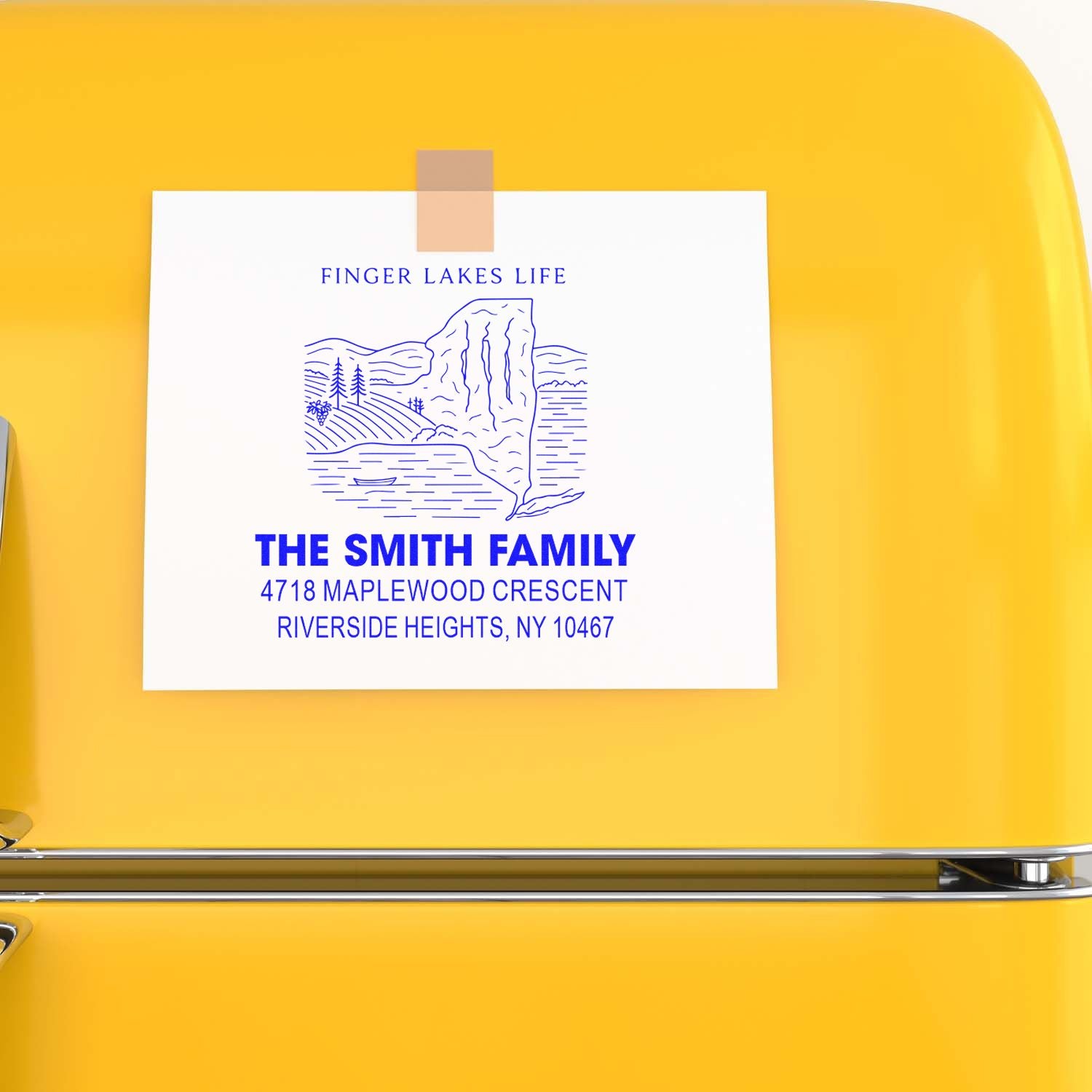 Custom rubber stamp for The Smith Family return address with Finger Lakes Life design, shown on a yellow surface.