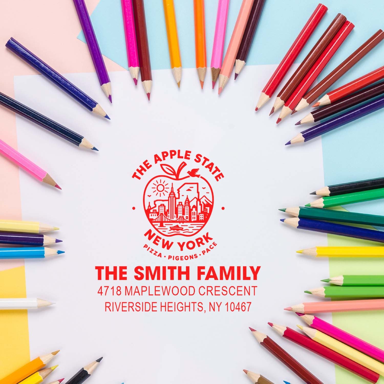Personalized family address rubber stamp with New York apple design, surrounded by colored pencils