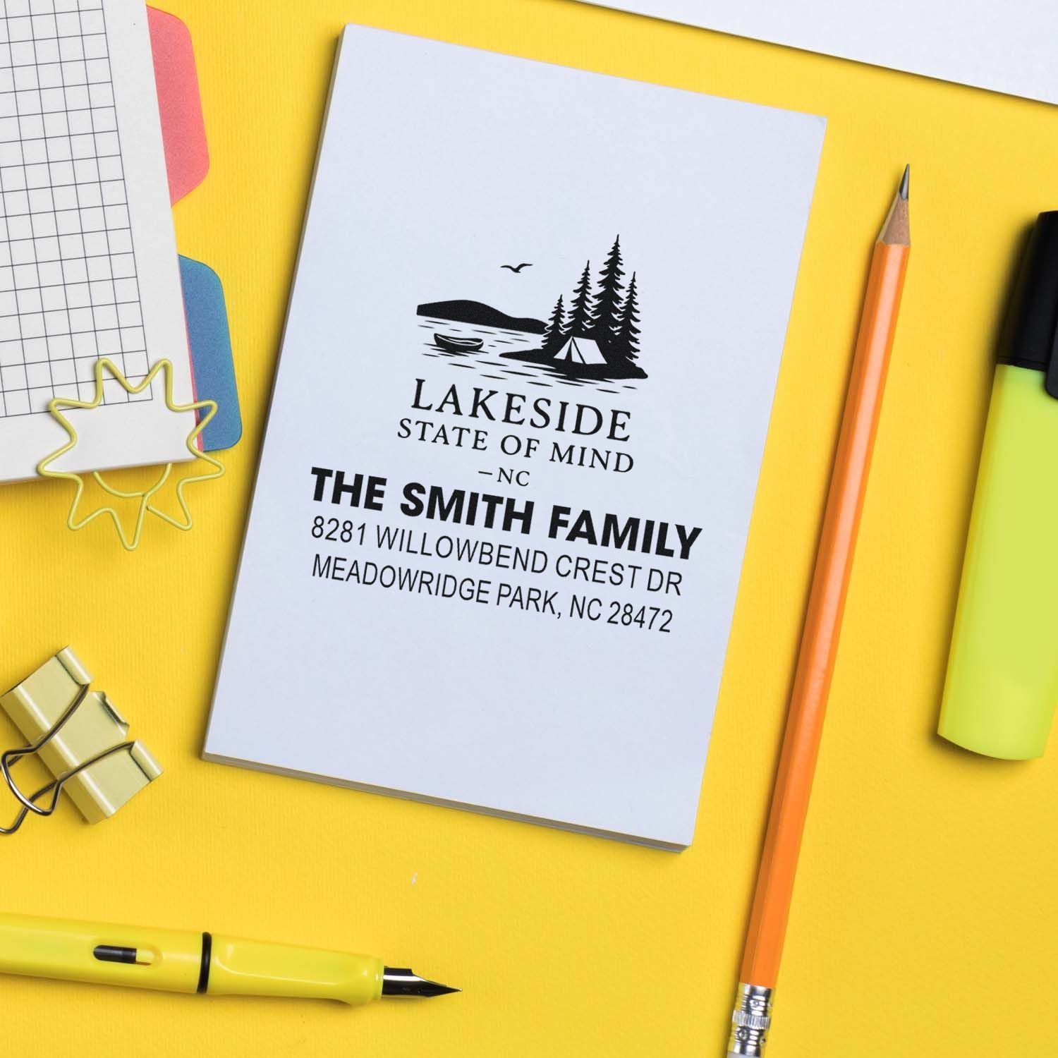 Custom rubber stamp sample with lakeside cabin logo and personalized return address for family stationery and mailings.