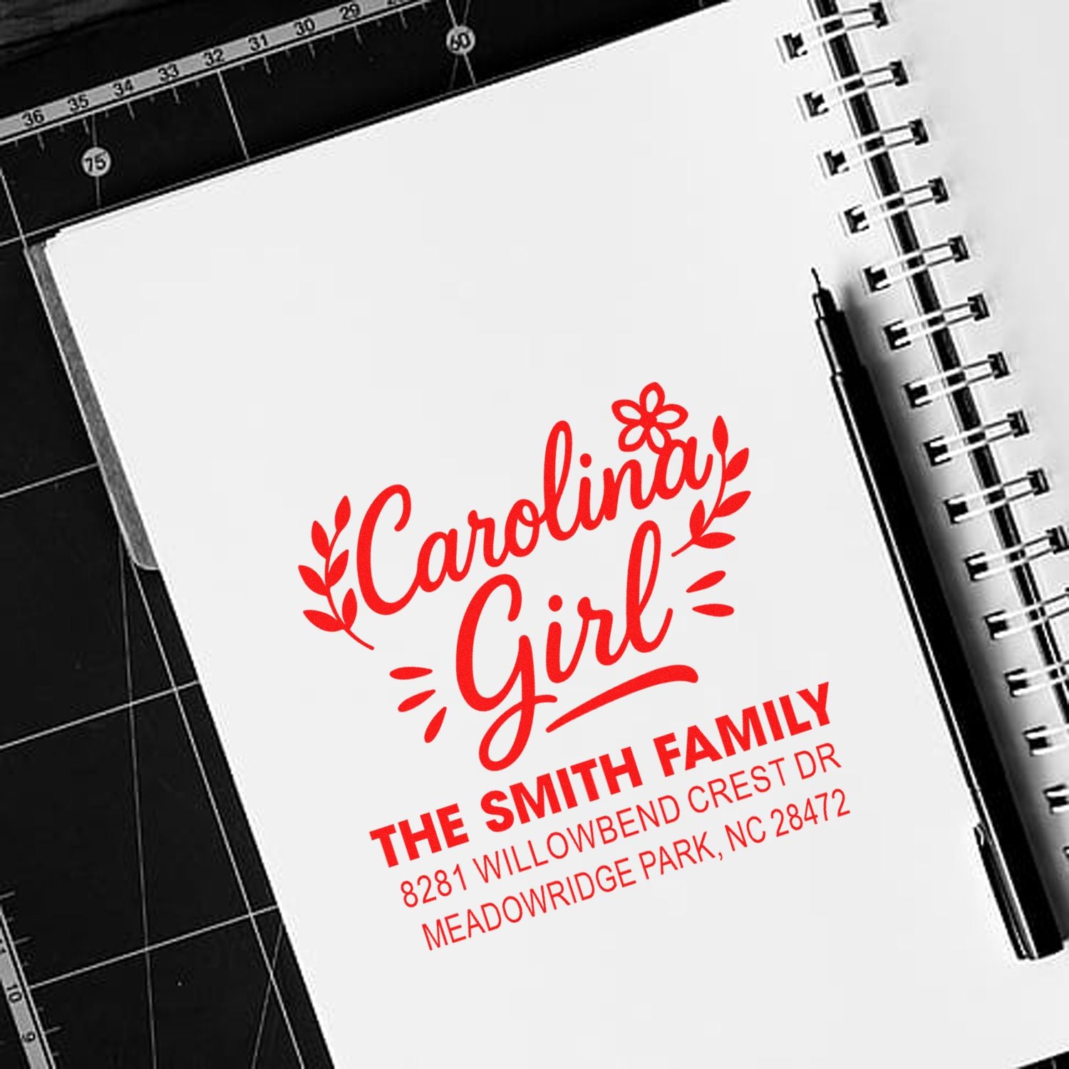 Personalized Carolina Girl rubber stamp with family name and address in red on a notebook page.