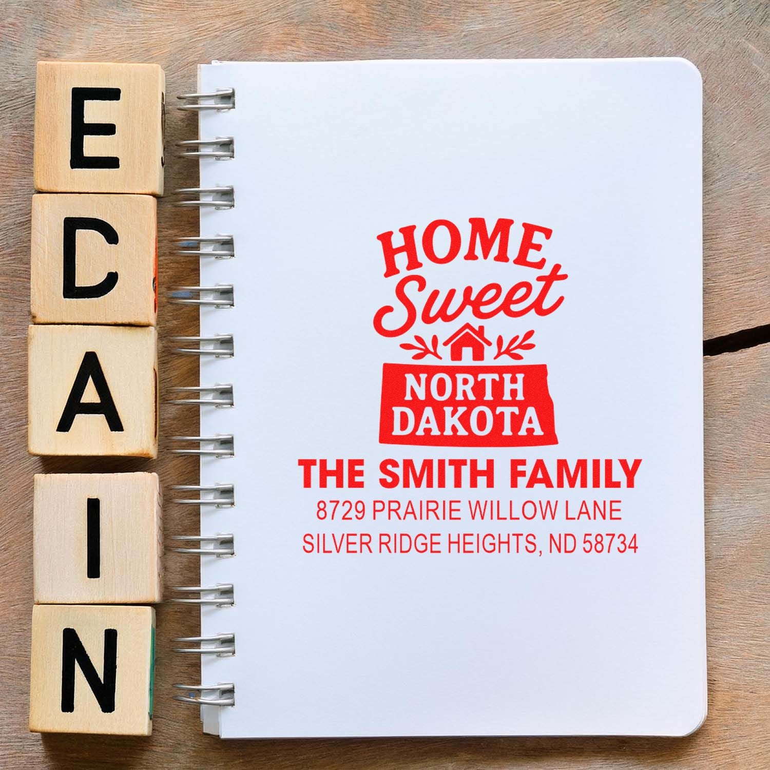 Personalized rubber stamp for a North Dakota family address, stamped on a notebook with Home Sweet North Dakota design.