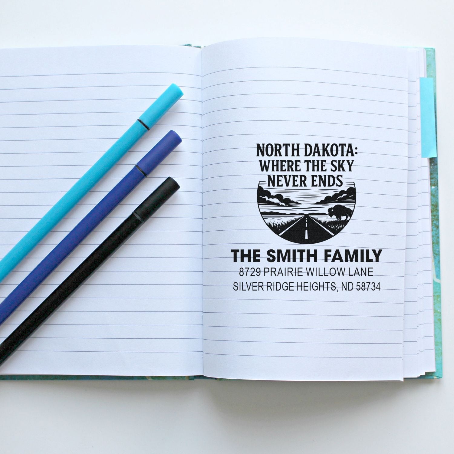 Personalized family return address rubber stamp with North Dakota design, stamped in a notebook for custom stationery.
