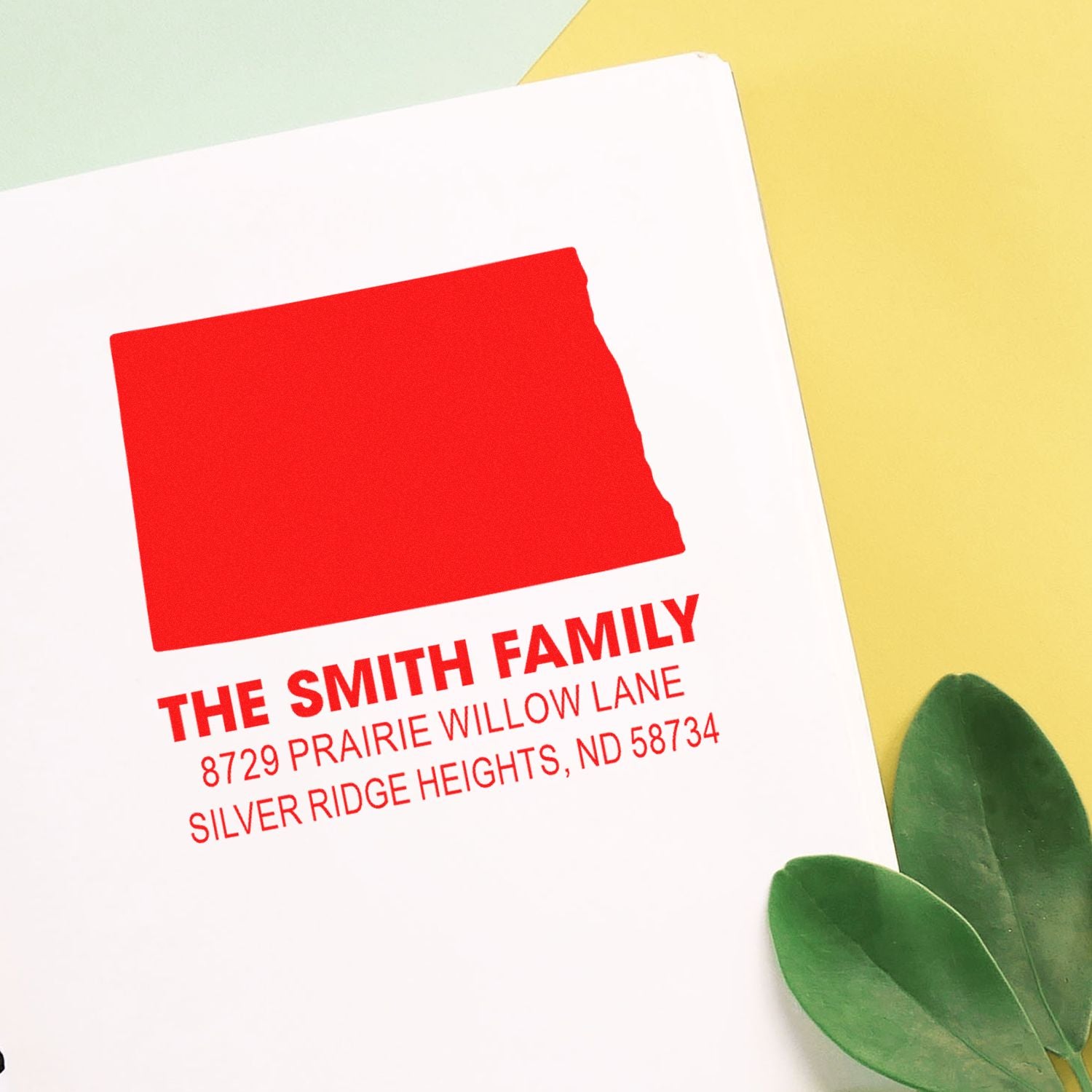 Custom return address rubber stamp for The Smith Family with name, street address, and city in bold red ink.