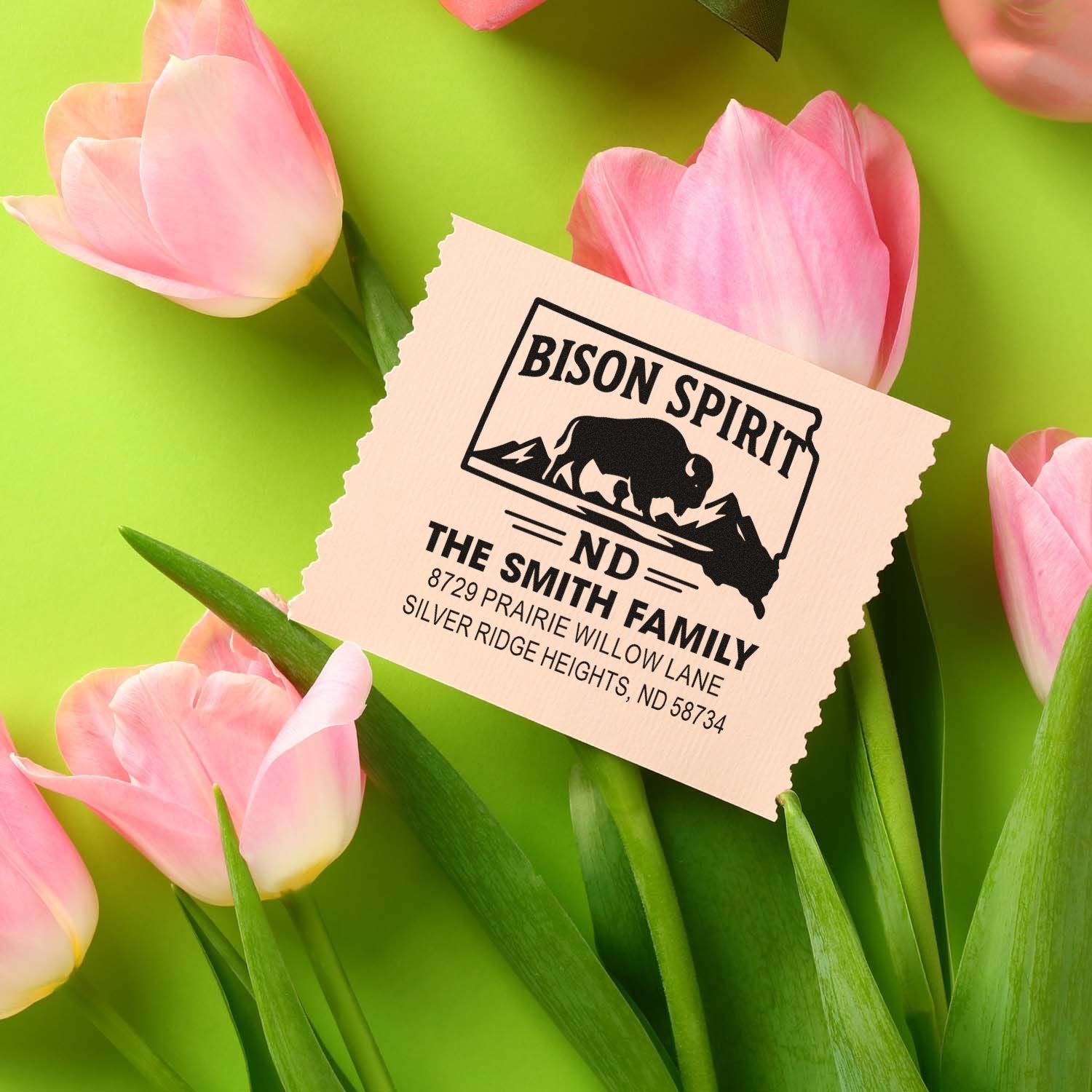 Custom address rubber stamp with bison spirit design, styled among pink tulips for a rustic family mailing stamp.