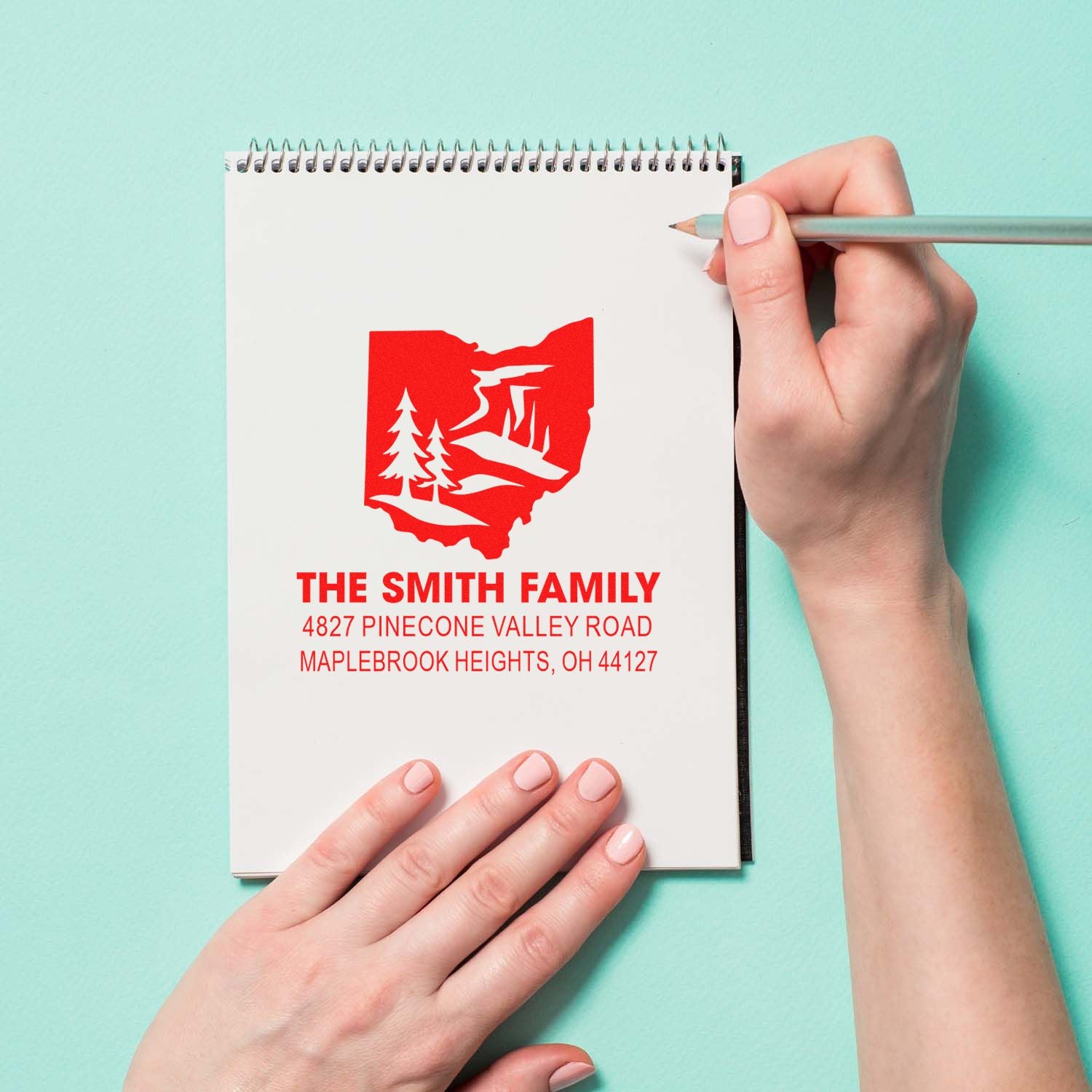 Custom family address rubber stamp with Ohio state tree design on a notebook, showing The Smith Family return address.