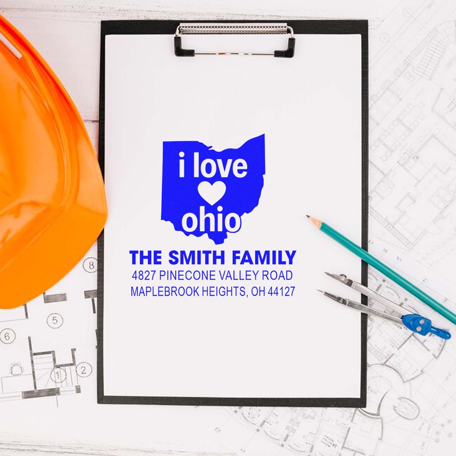 Custom Ohio return address rubber stamp for family mailings, shown on a clipboard with blueprint and drafting tools.