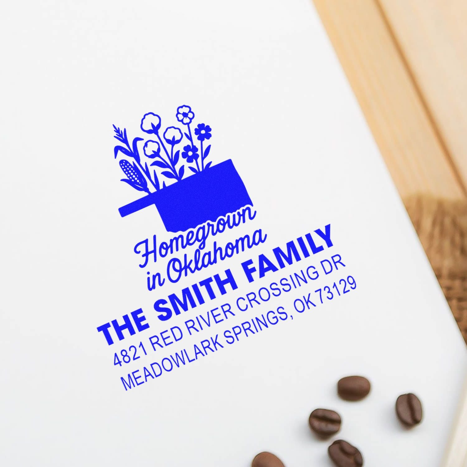 Custom address rubber stamp with floral pot logo for The Smith Family in Meadowlark Springs, OK, blue ink impression.
