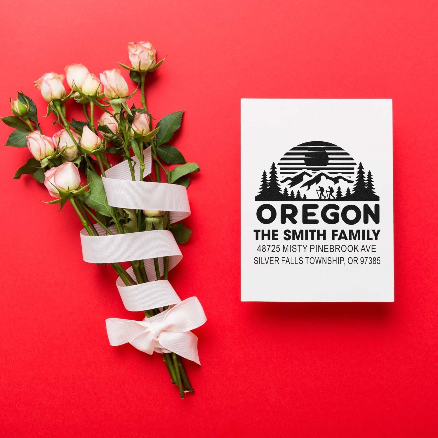 Personalized Oregon return address rubber stamp with mountain logo, shown beside a rose bouquet gift card.