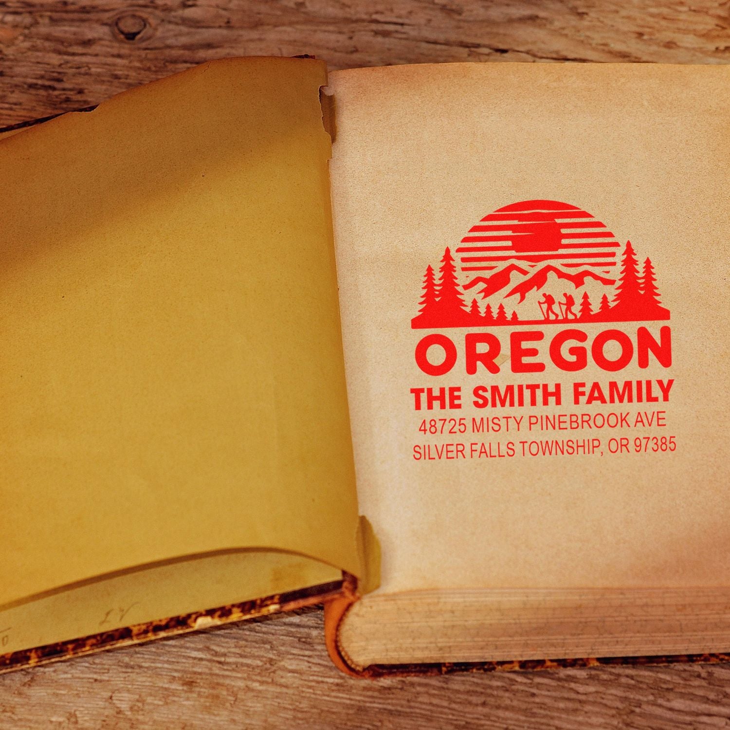 Personalized Oregon family address rubber stamp impression on an open book page.