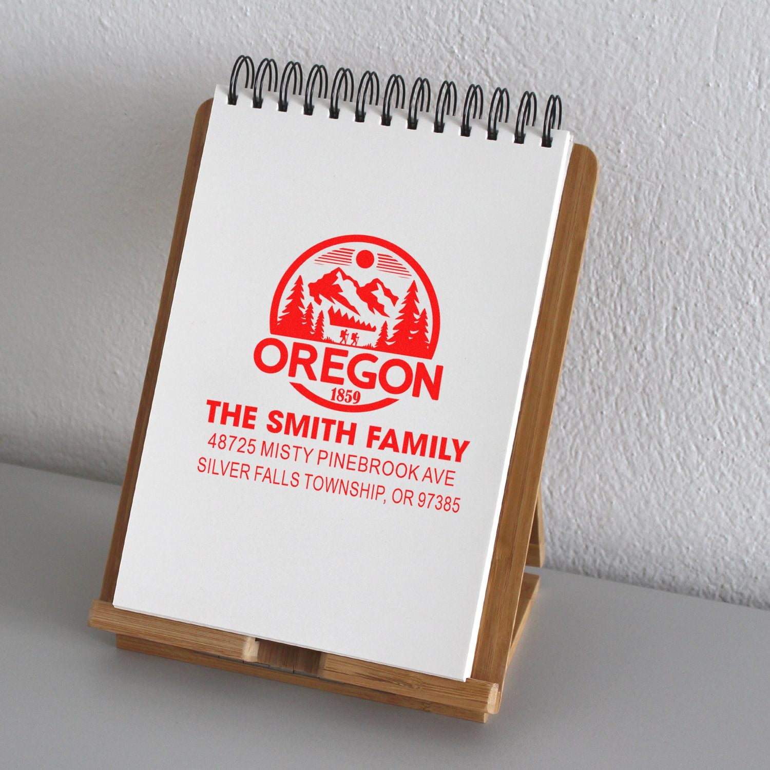 Custom Oregon return address rubber stamp on notepad display, featuring family name and mailing address.