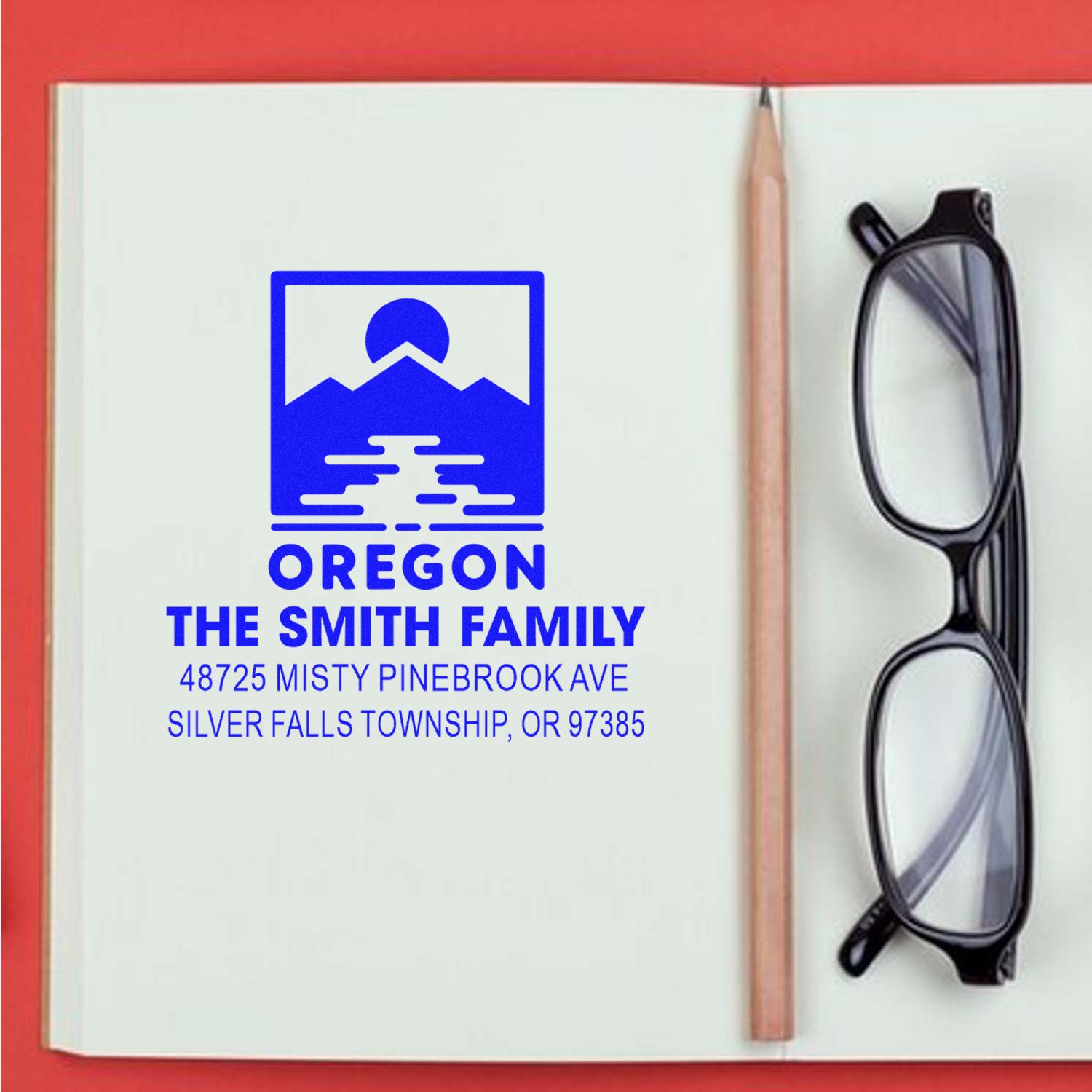 Custom Oregon family return address rubber stamp imprint on notebook, with mountain logo, pencil, and eyeglasses.