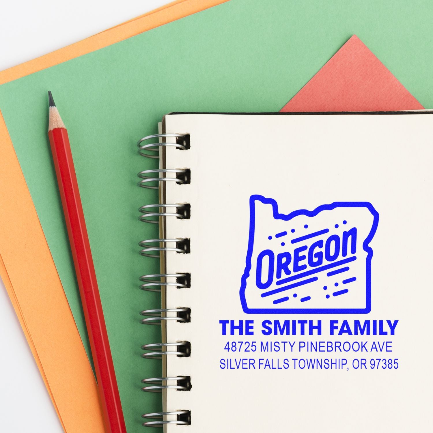 Custom Oregon return address rubber stamp for The Smith Family, shown on a notebook with Silver Falls Township address.