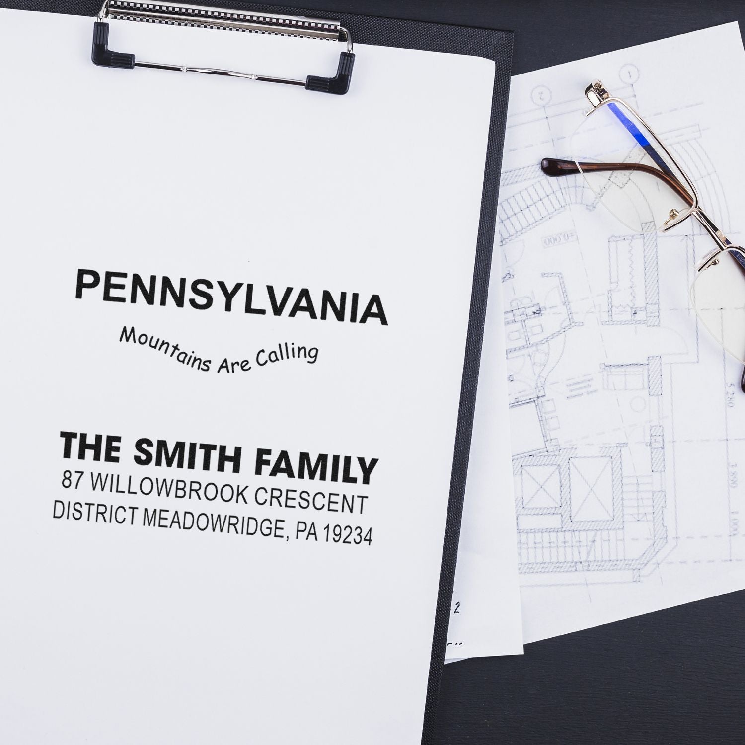 Custom rubber stamp design proofs for Pennsylvania and family address stamps displayed on clipboards with blueprint mockups.