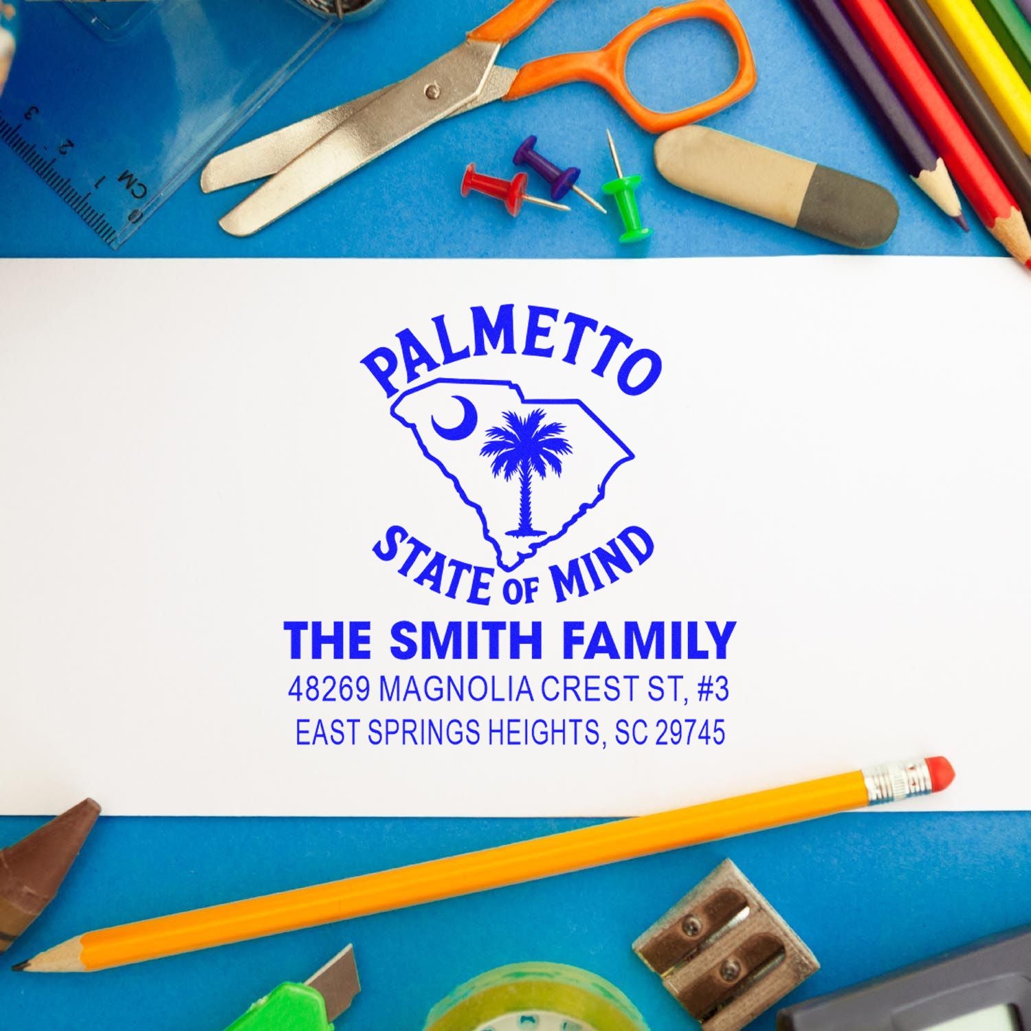Custom rubber address stamp with South Carolina design and Smith family return address, surrounded by school supplies.