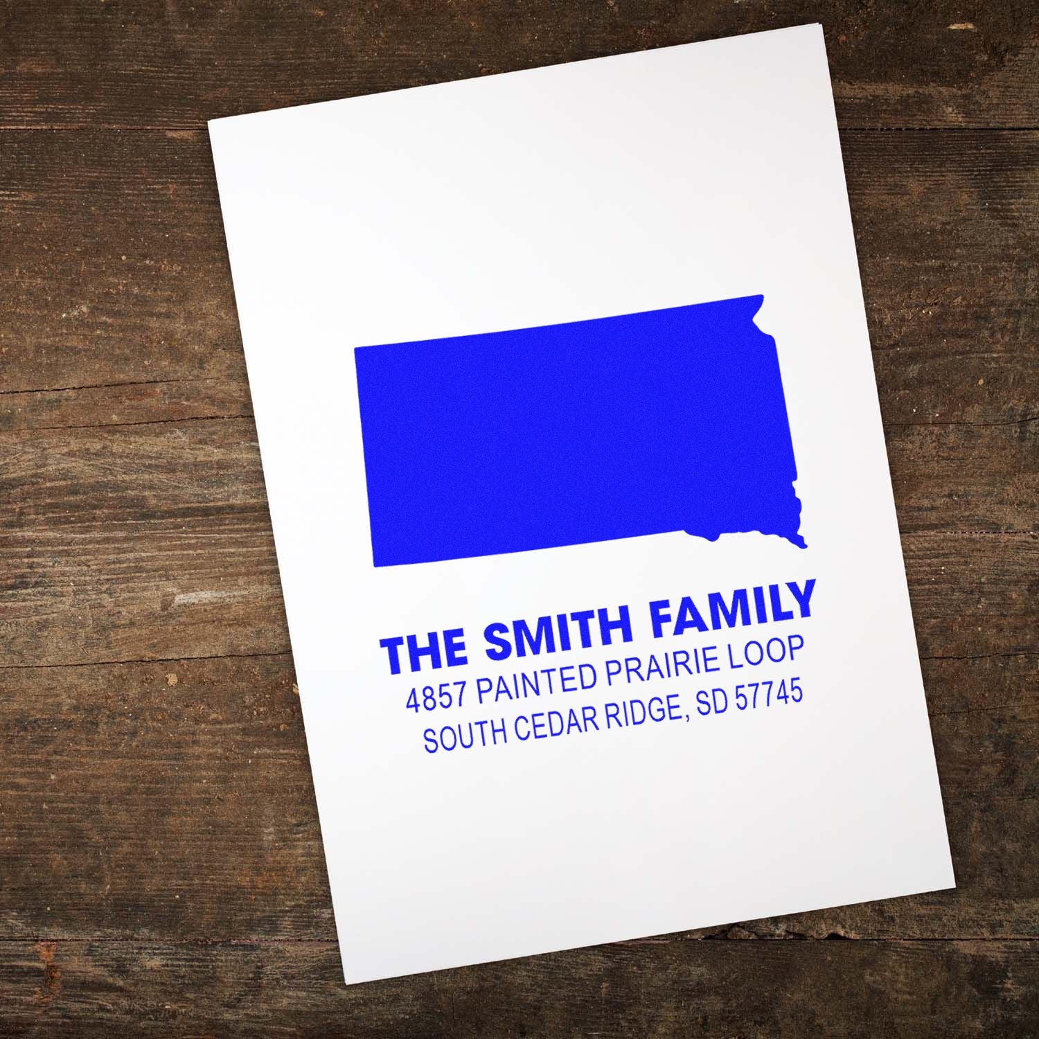 Custom address rubber stamp with South Dakota silhouette and The Smith Family return address in blue ink.