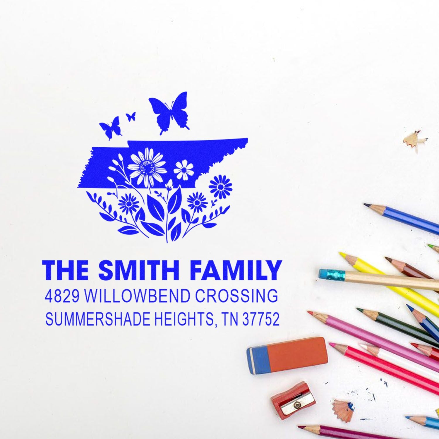 Custom rubber address stamp with Tennessee floral design, The Smith Family name and address, shown with colored pencils.