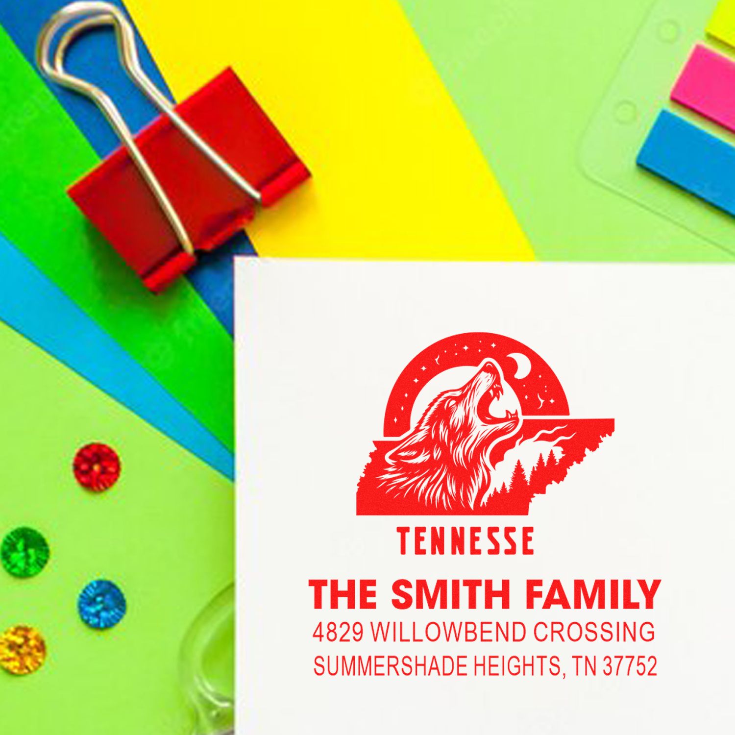 Custom Tennessee family return address rubber stamp with wolf logo, shown on colorful stationery and paper clips