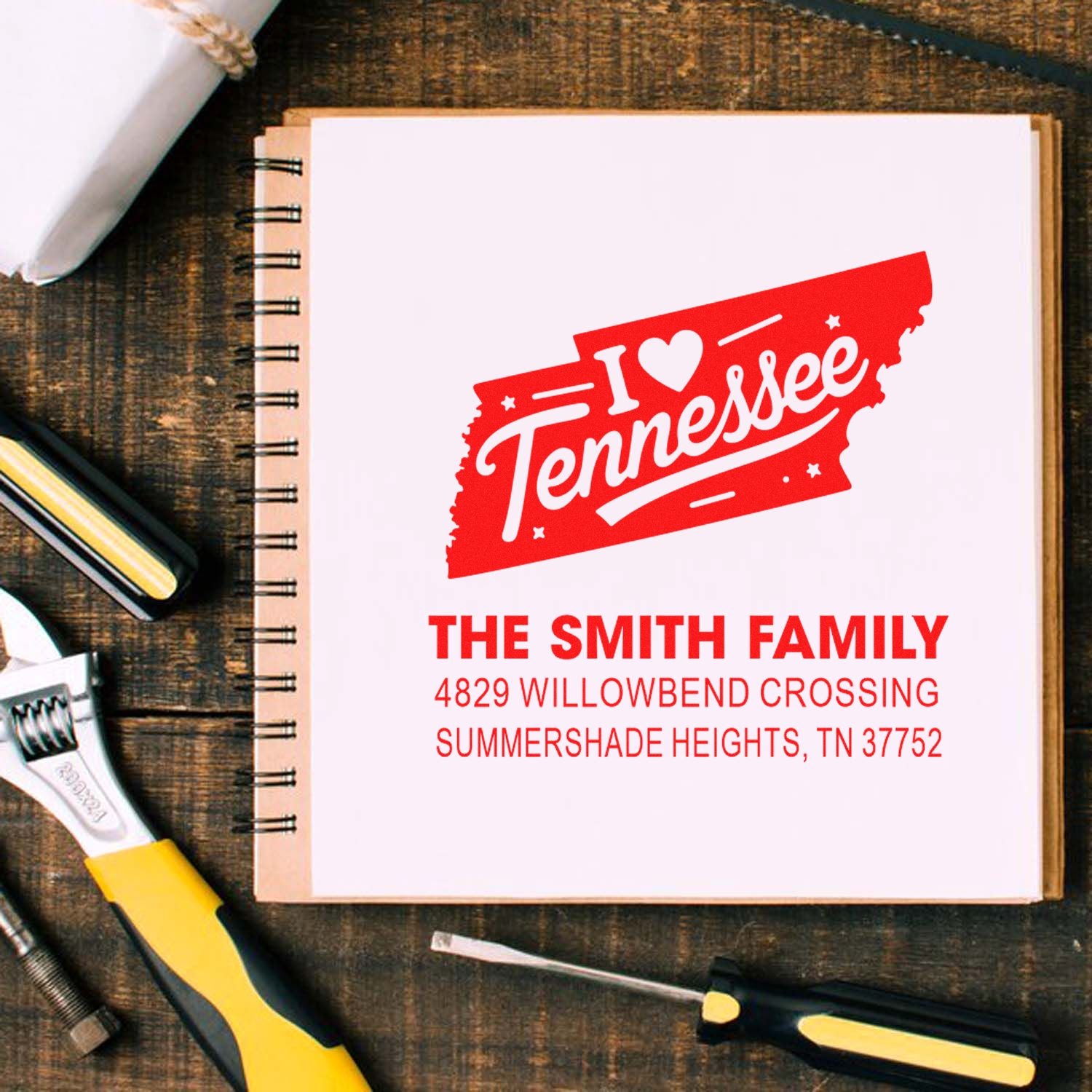 Custom rubber stamp with I Heart Tennessee design, family name, and address on notebook page.