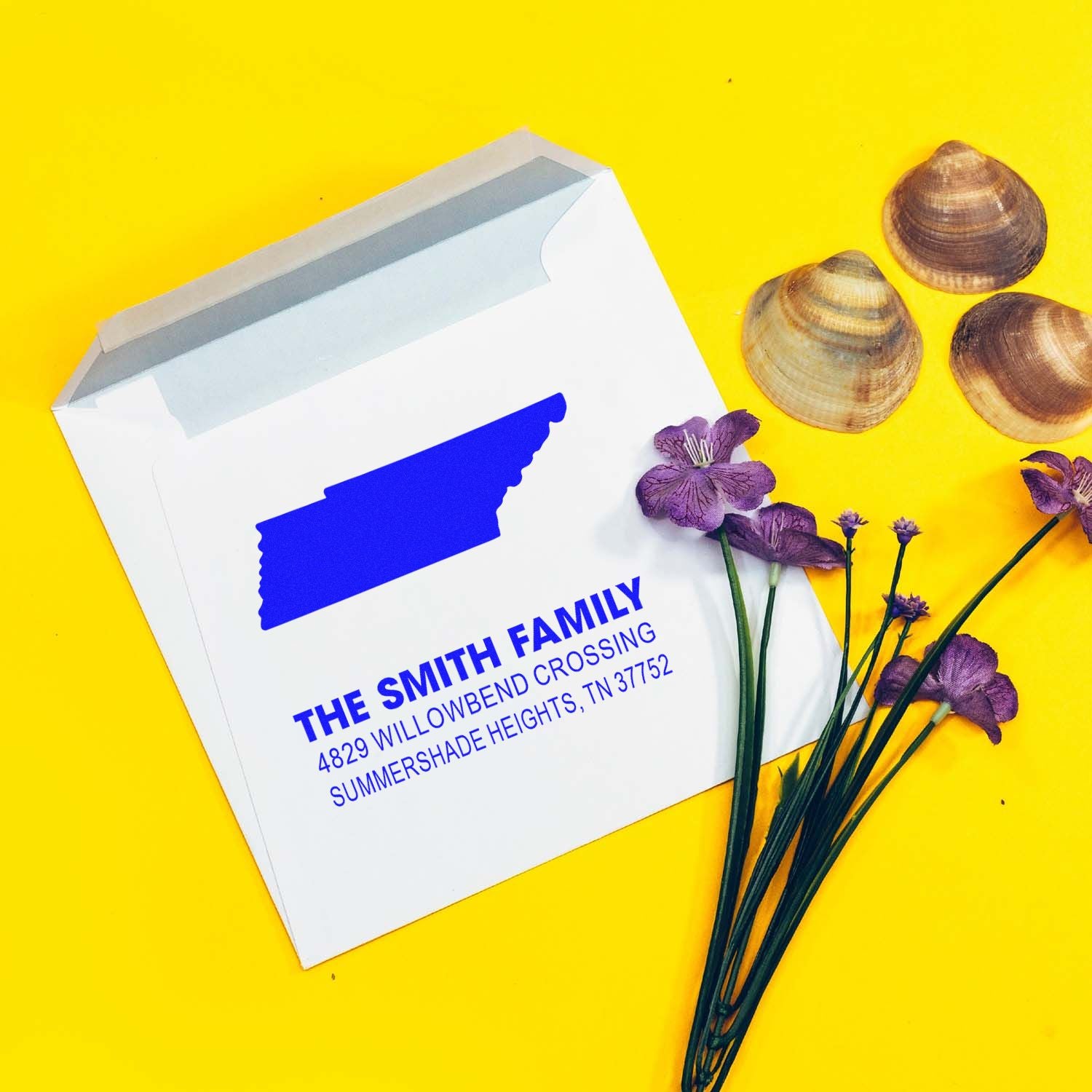 Personalized return address rubber stamp for The Smith Family, displayed on a white envelope with floral and shell decor.