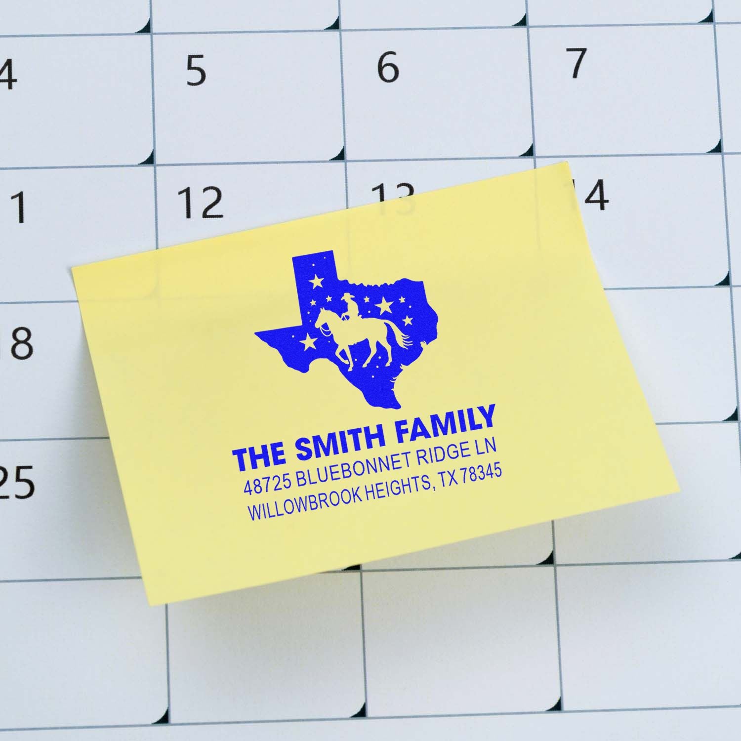 Custom Texas family address rubber stamp with horse silhouette on a note card over a calendar background.